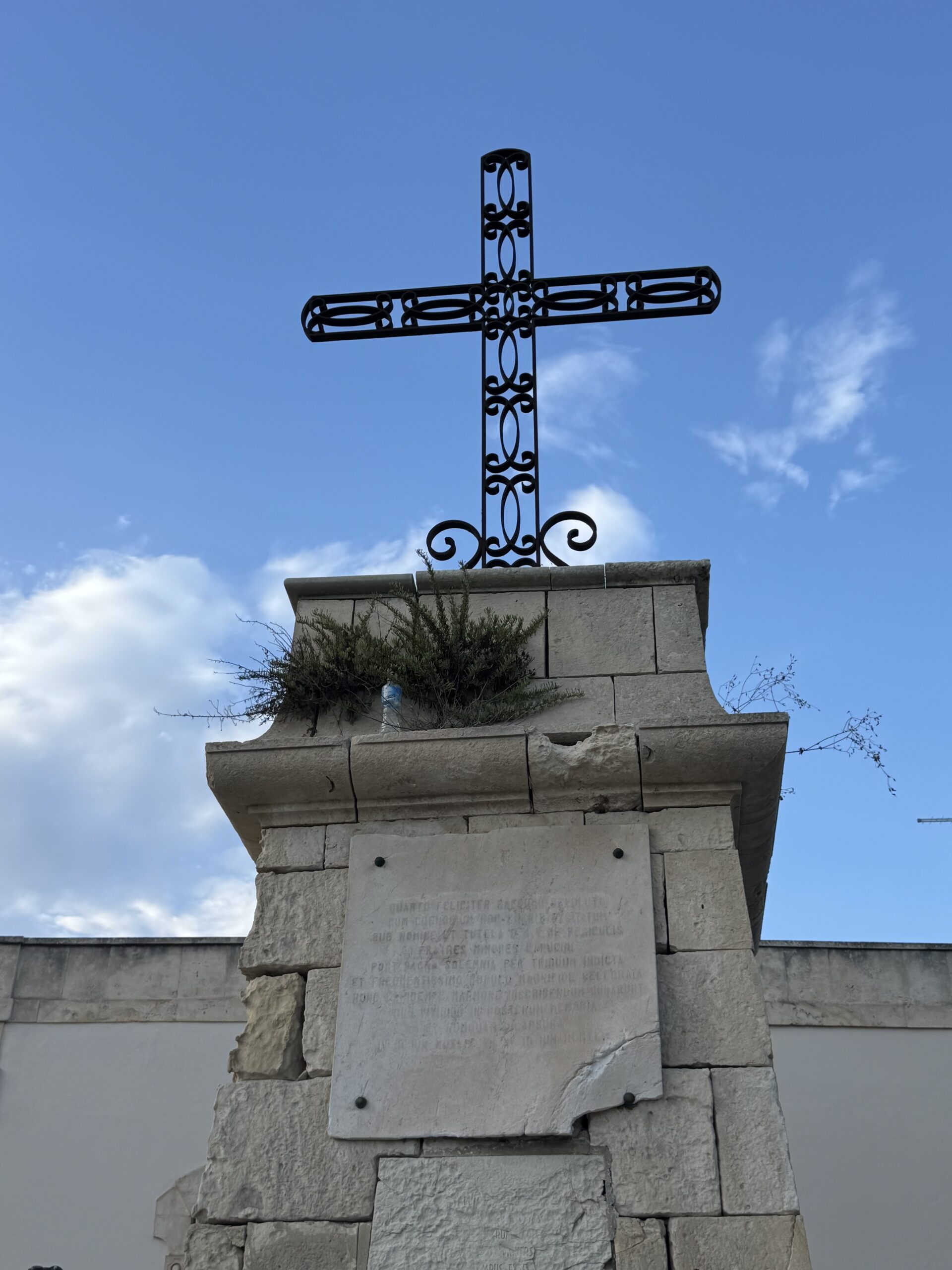Dettaglio della Croce delle Sante Missioni ai Cappuccini con la lapide marmorea e il basamento in pietra.