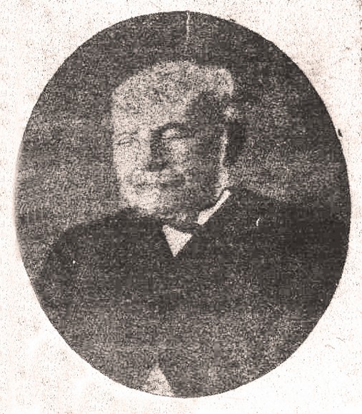 Ritratto ovale in bianco e nero di Carmelo Campisi anziano, con baffi bianchi e giacca scura.