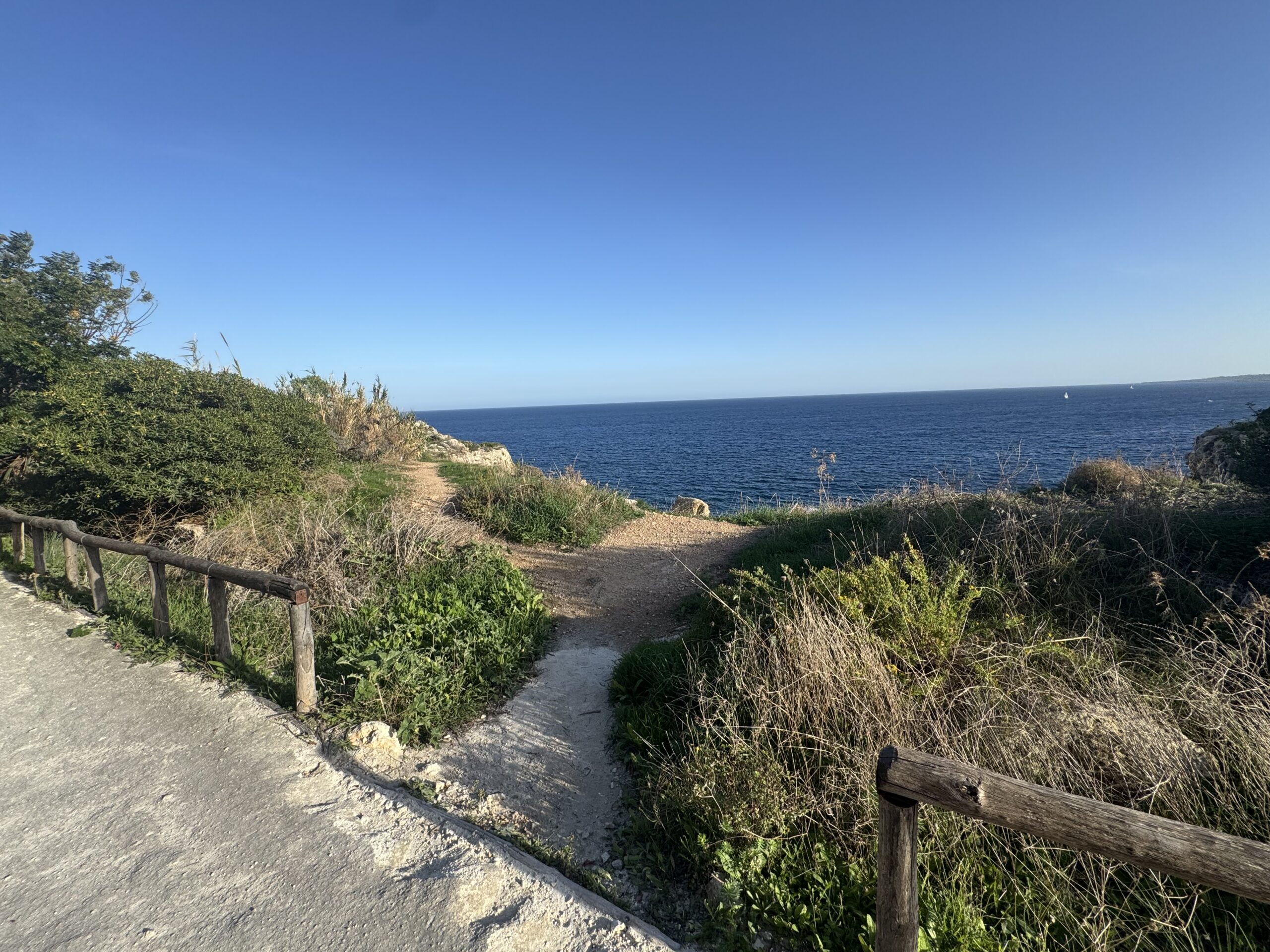 Uscita laterale sterrata dalla pista ciclopedonale Rossana Maiorca verso il ciglio della scogliera sul mare