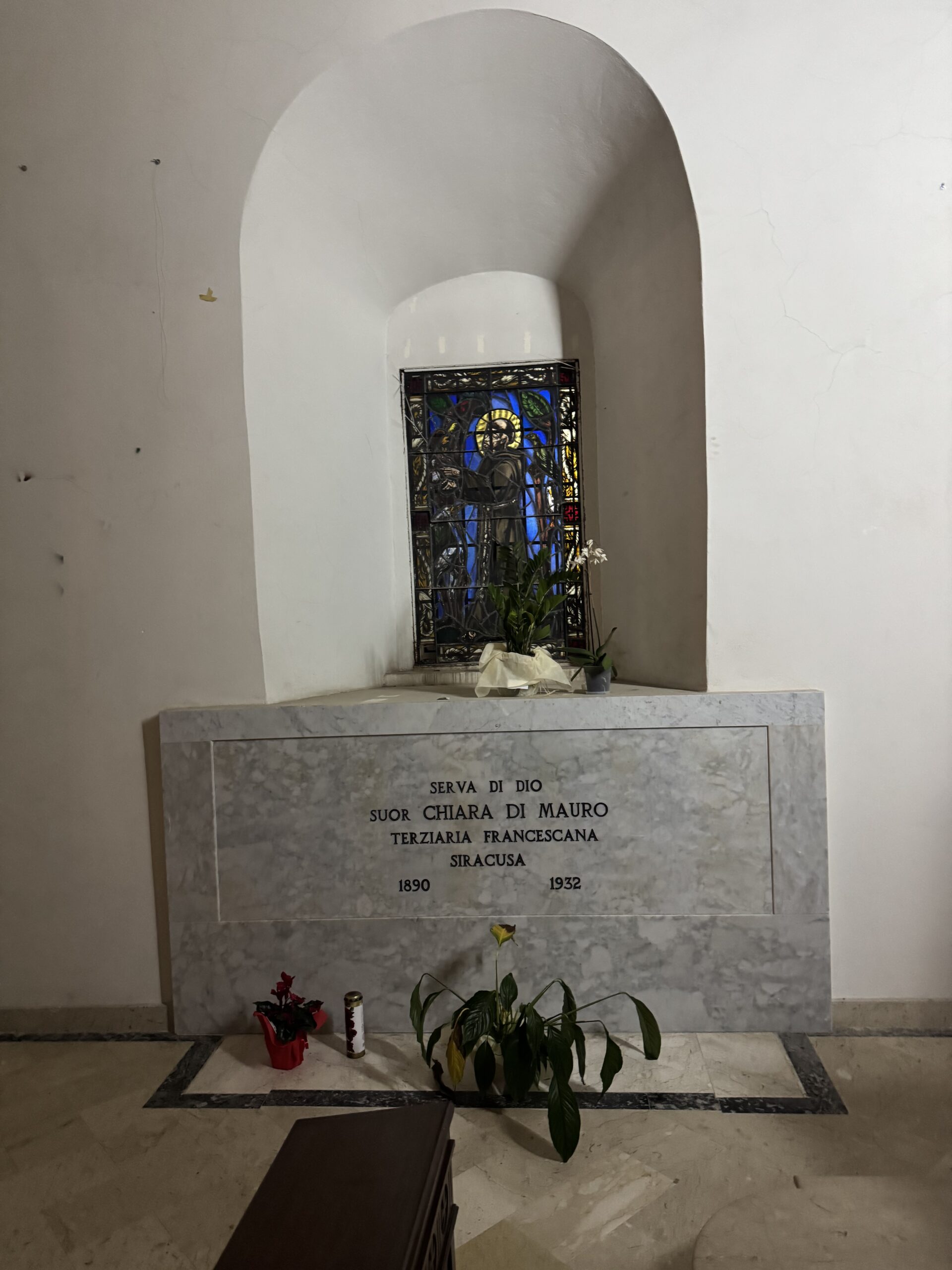 Lapide tombale di suor Chiara di Mauro con la vetrata di San Francesco sullo sfondo