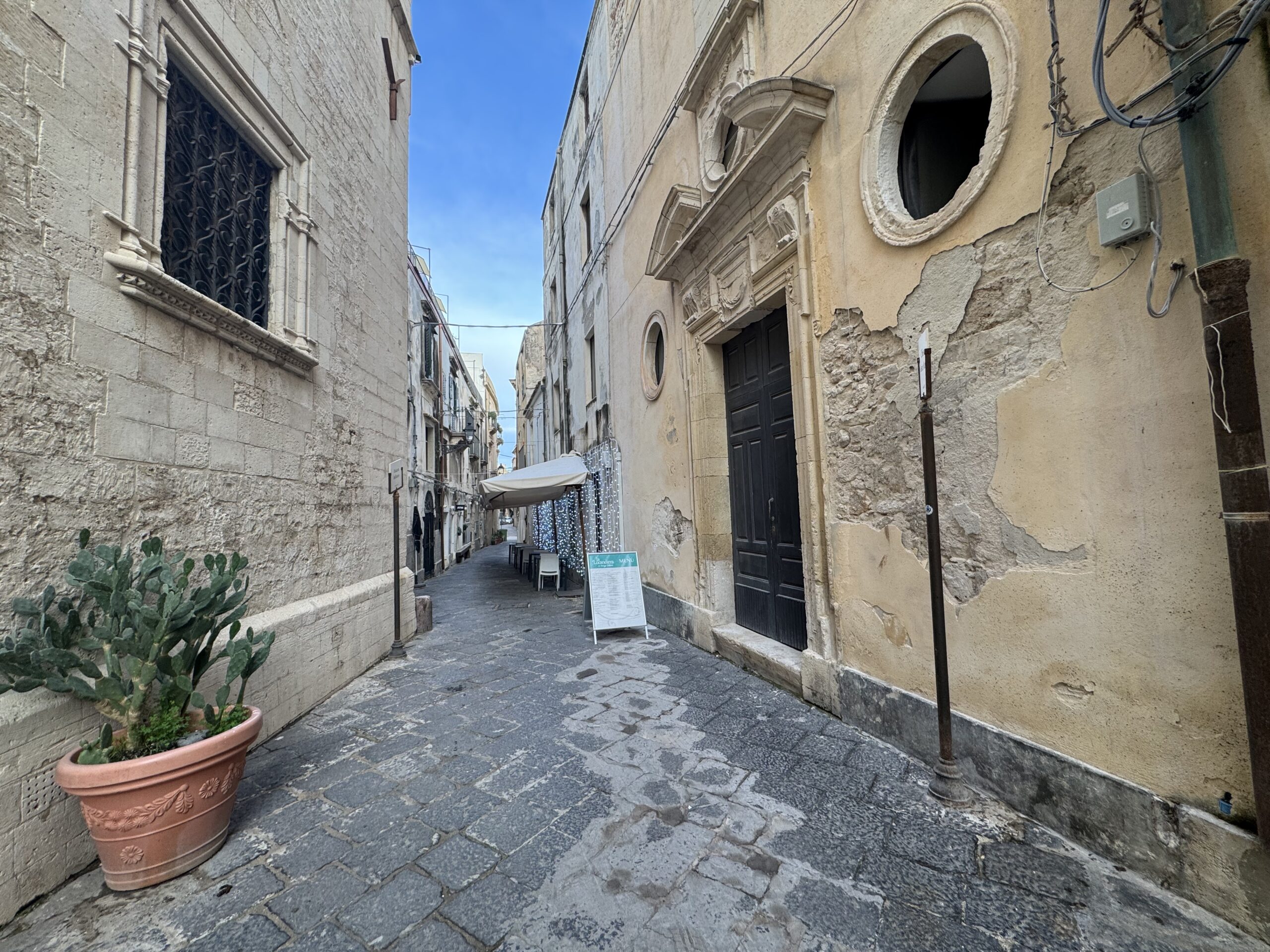 Gradino d’ingresso e basolato in pietra davanti alla ex chiesa di Gesù e Maria in via Capodieci, Ortigia.