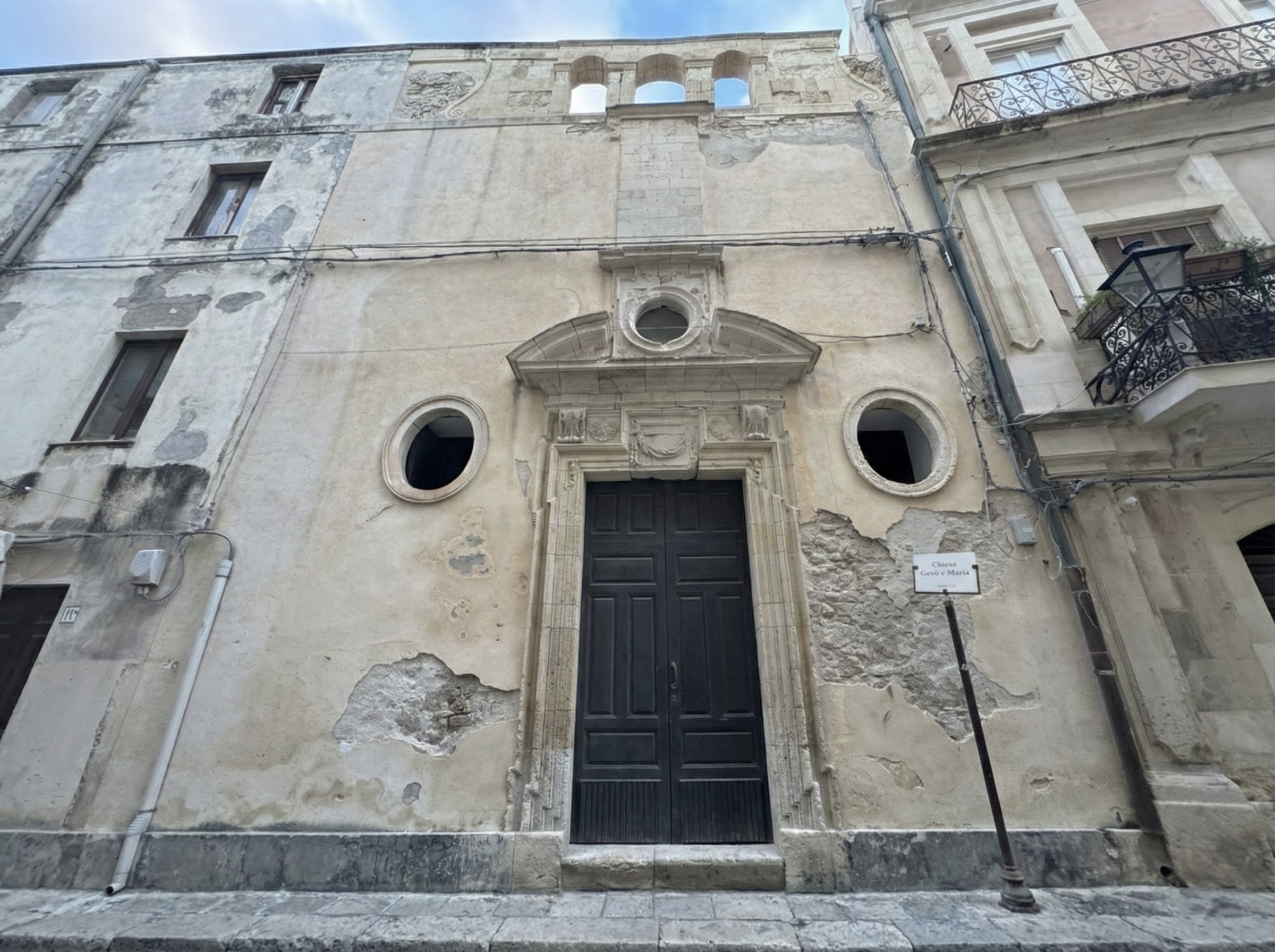 Facciata seicentesca della chiesa di Gesù e Maria a Siracusa, ripresa in modo panoramico con il portale barocco e l’intera estensione della facciata su via Capodieci.