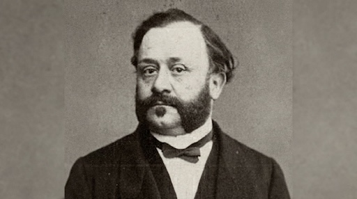 Ritratto in bianco e nero di Gaetano Moscuzza, con barba e baffi, in abito scuro e papillon.