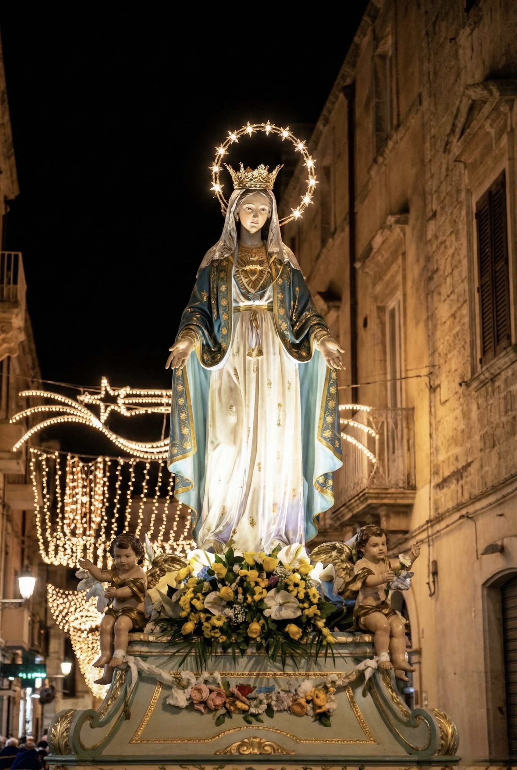 Simulacro dell’Immacolata durante la processione serale per le vie di Ortigia, illuminato dalle luminarie.
