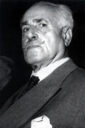 Ritratto formale di Eduardo Di Giovanni in età matura con abito scuro