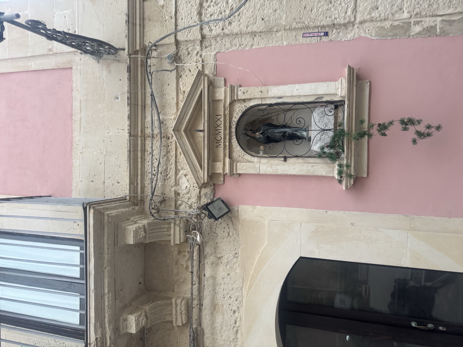 Scorcio dell'edicola votiva di Maria SS. Addolorata con la nicchia in pietra calcarea e il frontone triangolare, vista da un'angolazione laterale lungo Vicolo delle Pergole nel quartiere della Giudecca a Ortigia