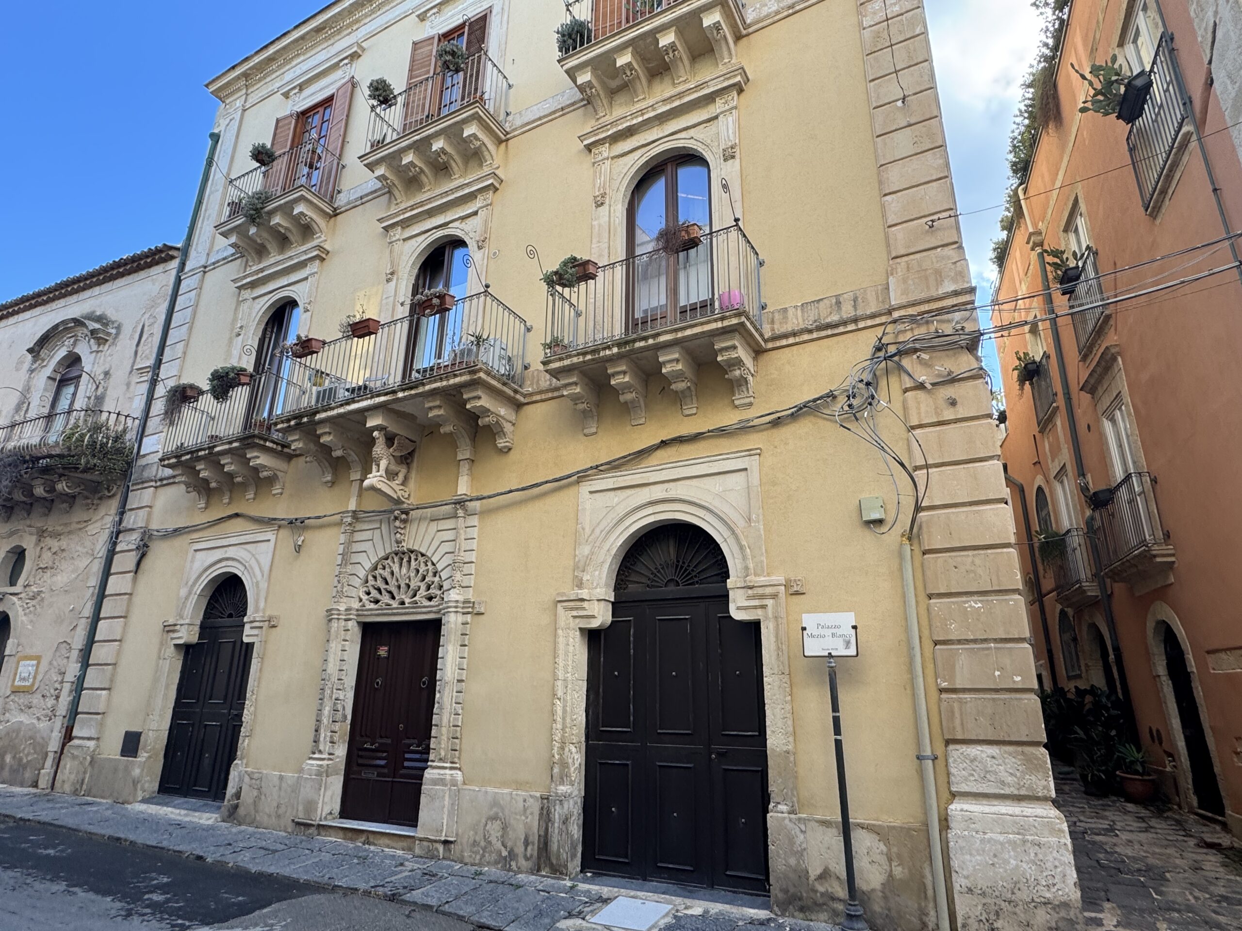 Dettaglio dell'edicola votiva di Sant'Antonio da Padova in nicchia a conchiglia tra i portali del palazzo