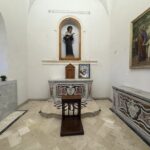 Vista frontale dell'altare in marmo policromo della Cappella di Santa Rita, con la statua lignea della santa nella nicchia centrale arcuata e il pavimento davanti all'altare decorato con un raggio nero policromo a ventaglio