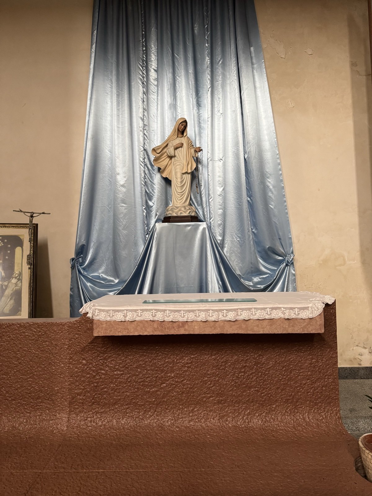 Cappella della Madonna nella Chiesa di Santa Rita a Siracusa: statua mariana in gesso dipinto, drappo azzurro di fondo, altare con tovaglia bianca