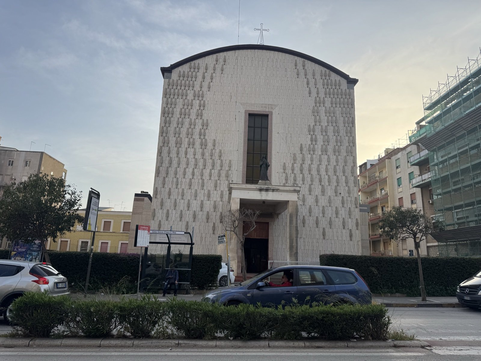 Prospettiva della Chiesa di Santa Rita vista frontalmente da corso Gelone con la pensilina del bus in primo piano