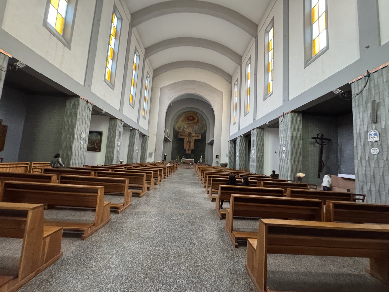 Interno della Chiesa di Santa Rita a Siracusa: navata unica vista verso il presbiterio, con volta a botte, vetrate laterali policrome e crocifisso ligneo sul fondo