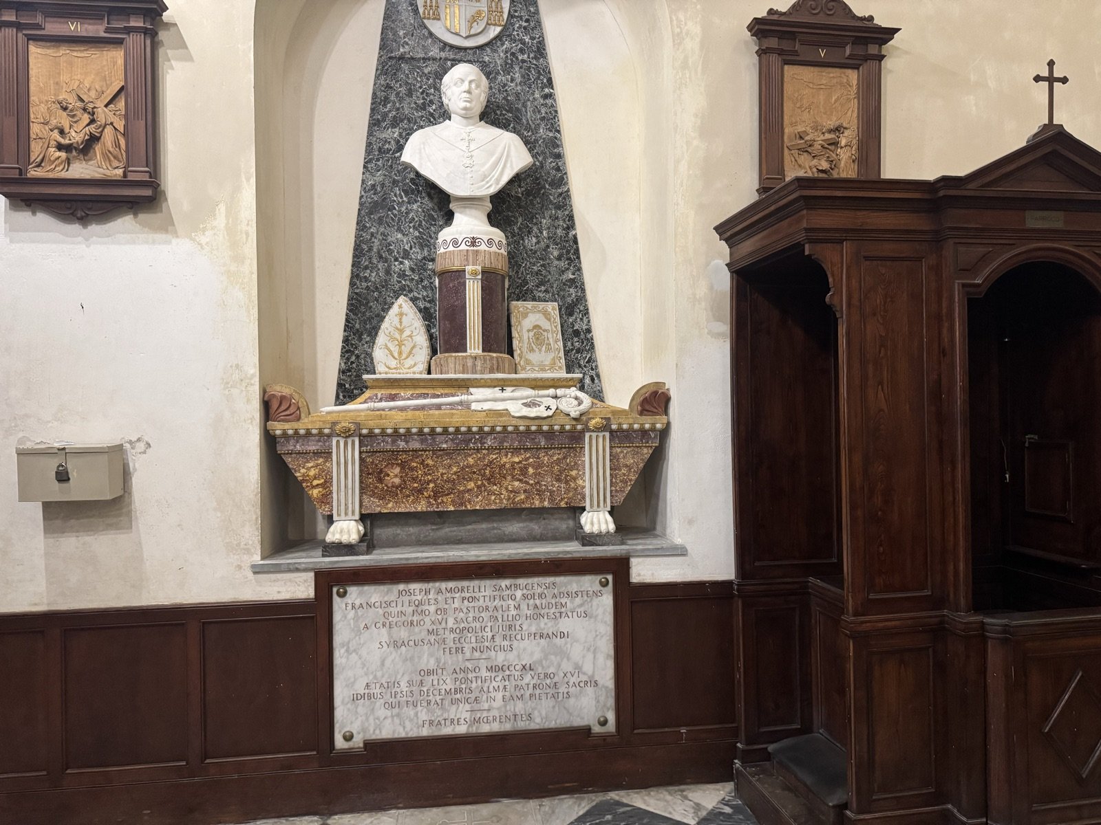 Monumento sepolcrale dell'arcivescovo Giuseppe Amorelli con busto marmoreo bianco su fondo verde e sarcofago in marmi policromi su zampe di leone