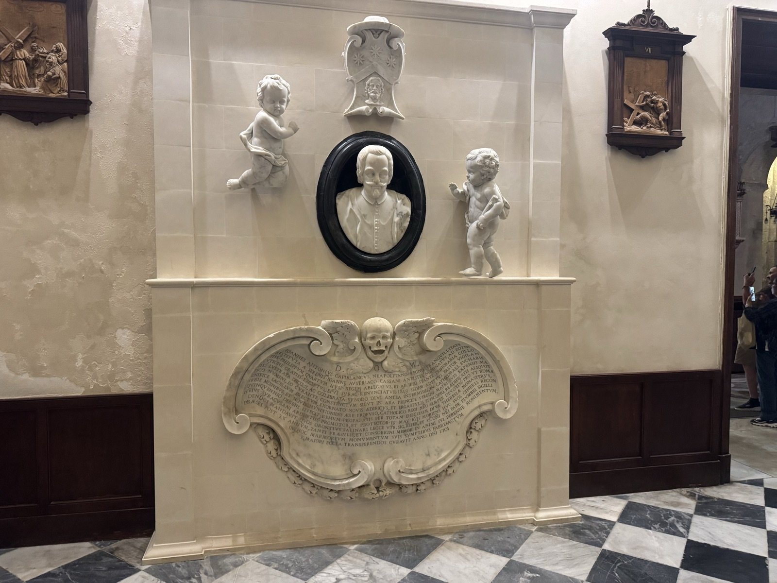 Monumento marmoreo dei fratelli Capoblanco del 1701 con ritratto a olio in cornice ovale del vescovo, due putti marmorei ai lati e cartella barocca con teschio alato