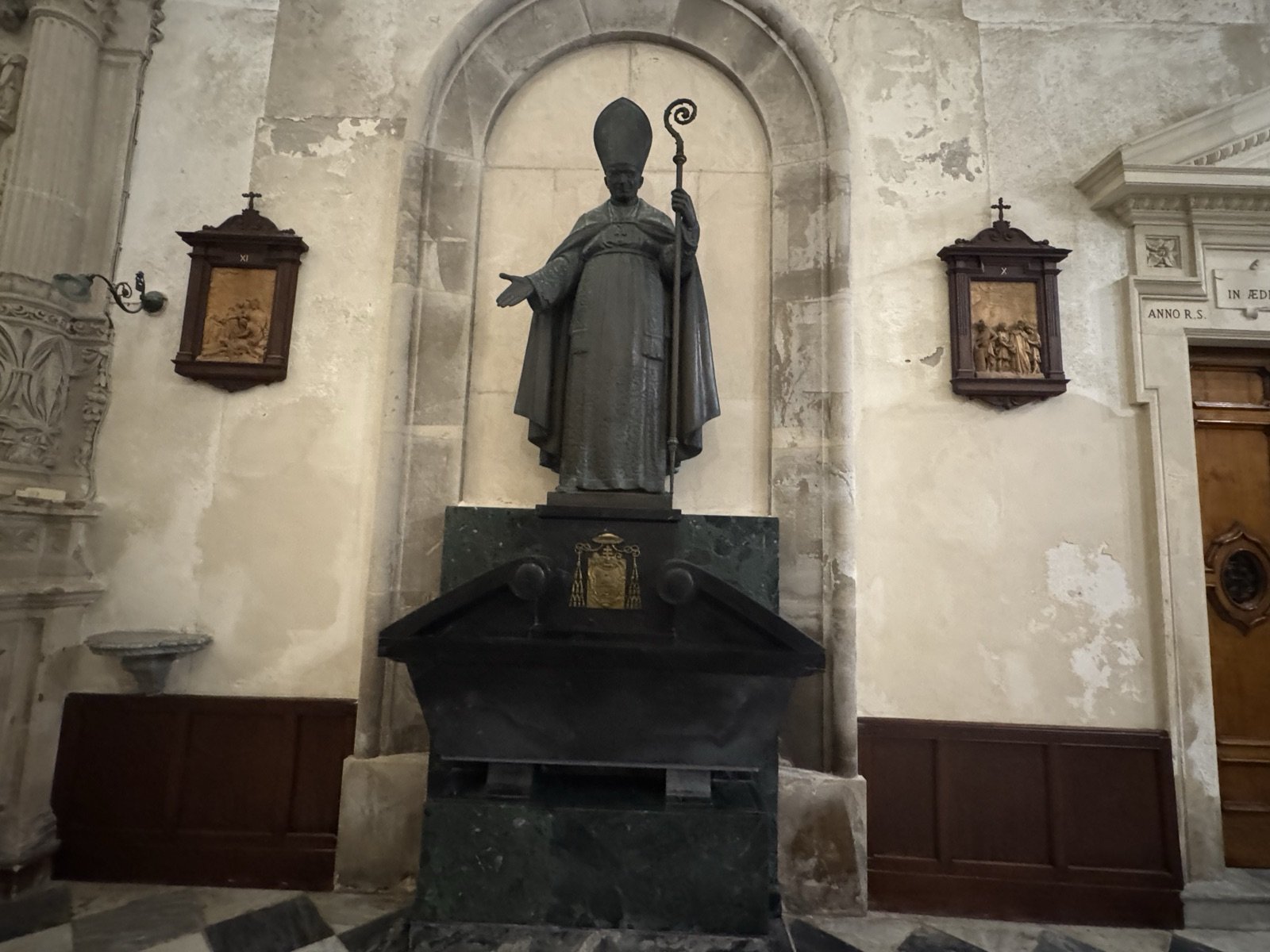 Statua bronzea dell'arcivescovo Giacomo Carabelli con mitra e pastorale in nicchia ad arco a tutto sesto, opera di Pasquale Sgandurra