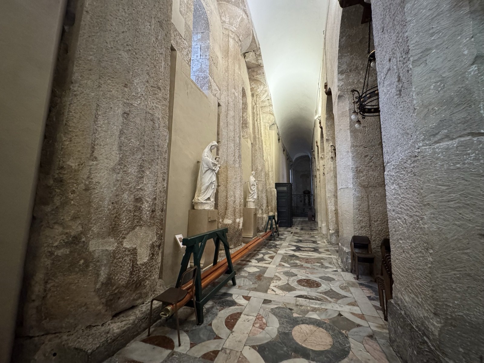 Navata sinistra del Duomo di Siracusa con colonne doriche del tempio greco di Atena del V secolo a.C. inglobate nelle pareti, statue di santi in nicchia, pavimento in marmi policromi