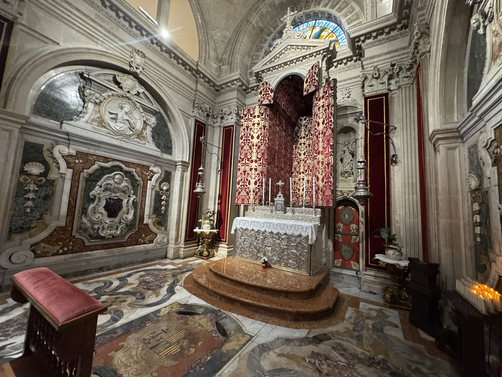 Vista di un altare laterale della Cappella del Santissimo Sacramento con drappo rosso ricamato e tabernacolo argentato