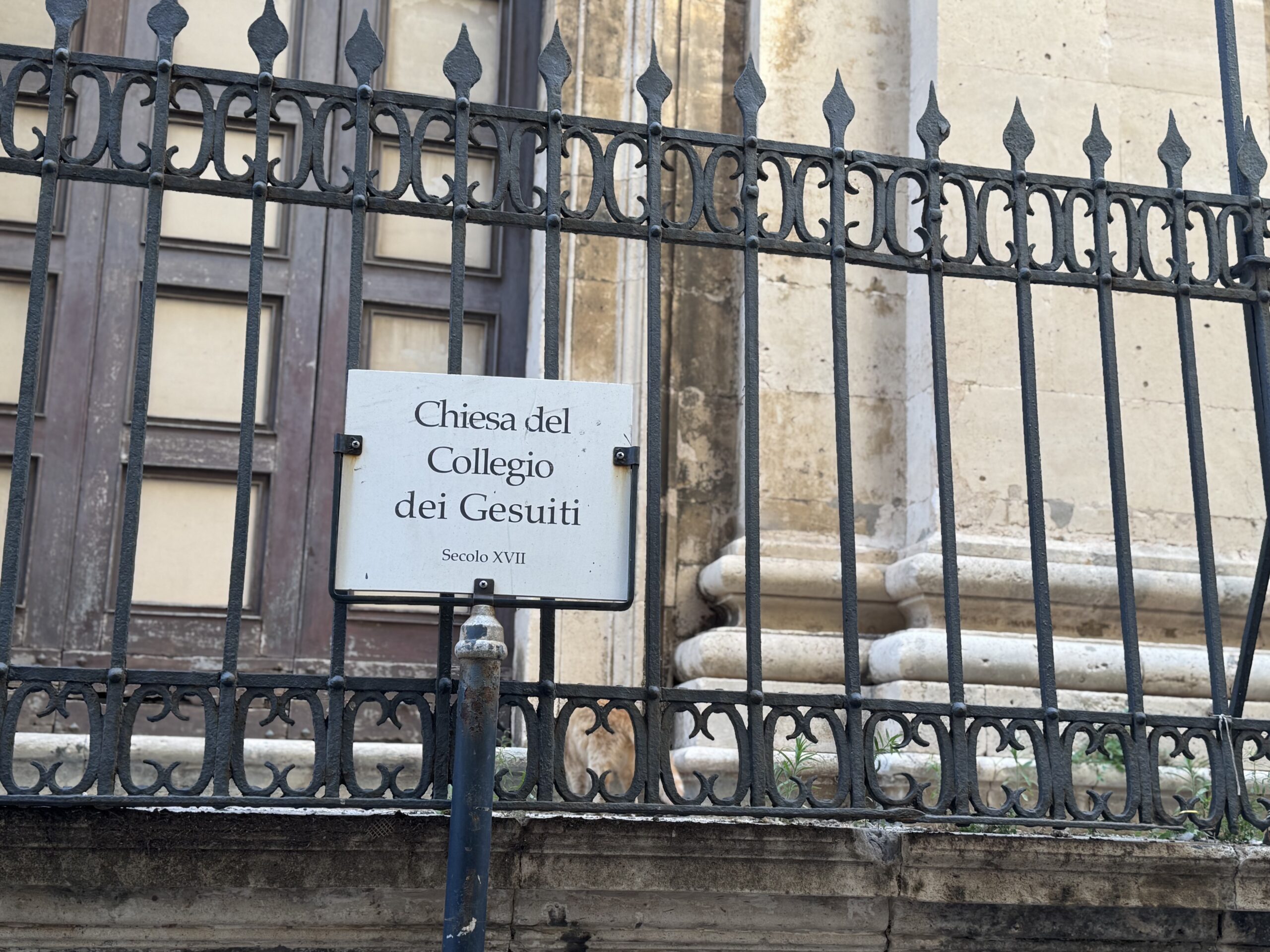 Dettaglio della targa Chiesa del Collegio dei Gesuiti, Secolo XVII, montata sulla cancellata in ferro battuto del sagrato
