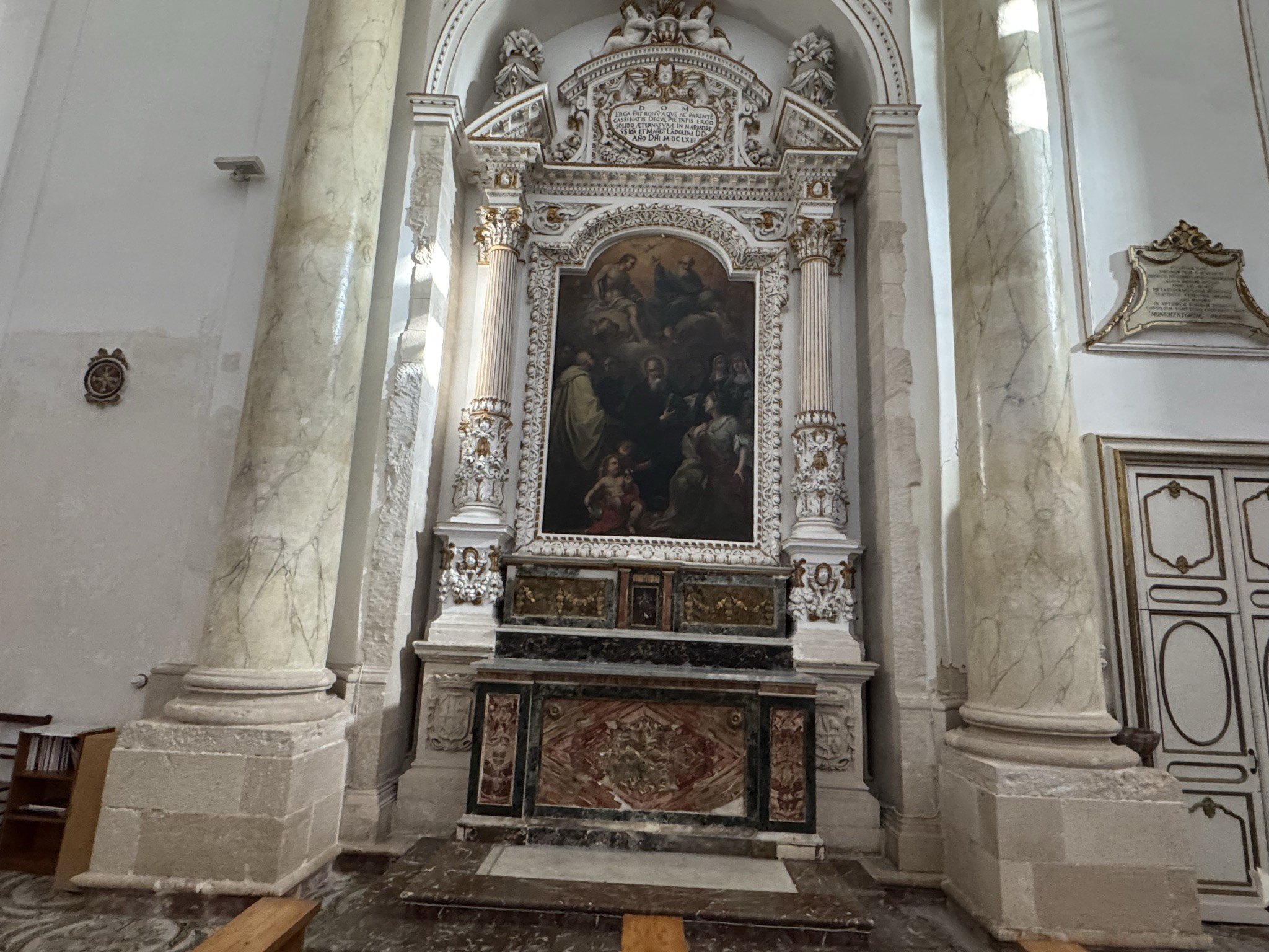 Altare laterale della chiesa di Santa Maria della Concezione con pala raffigurante una scena della Sacra Famiglia o di santi, cornice intagliata bianca e dorata, paliotto in marmi mischi.