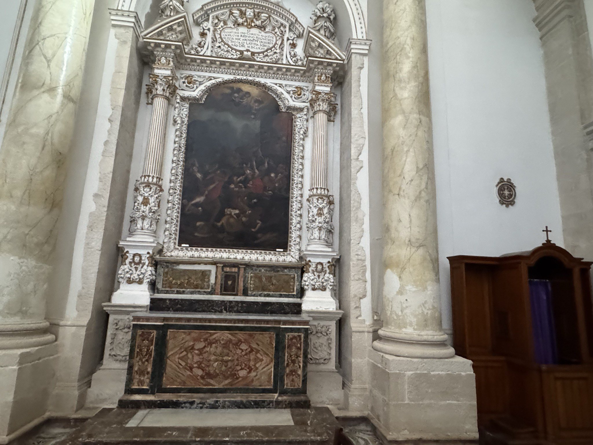 Altare laterale con pala raffigurante una scena di martirio o strage, cornice intagliata, iscrizione superiore e paliotto in marmi mischi policromi.