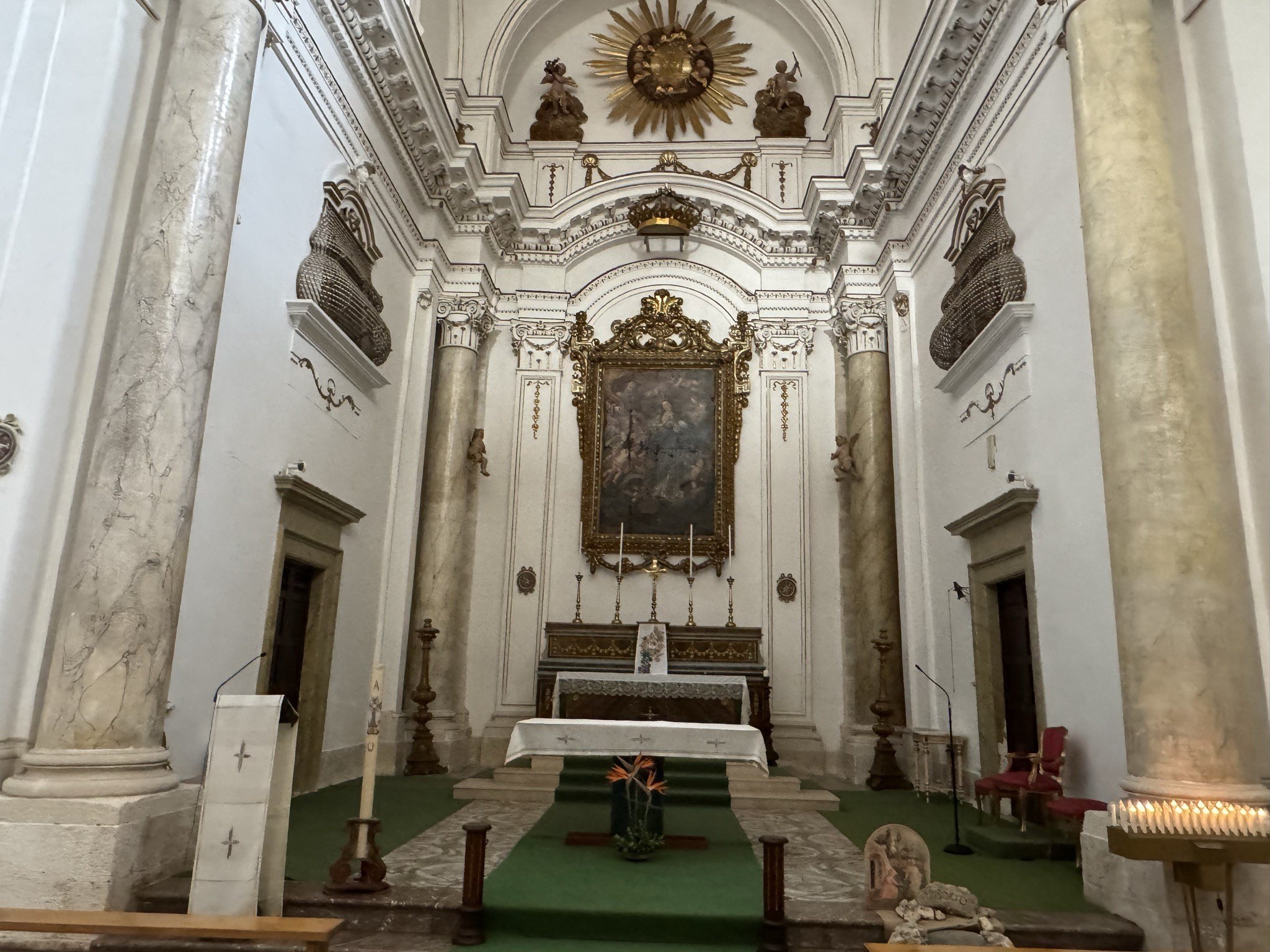 Altare maggiore con pala dell'Immacolata in cornice dorata, grande raggiera dorata in stucco con monogramma mariano e balconcini-grate laterali con gelosie dorate per le monache di clausura.