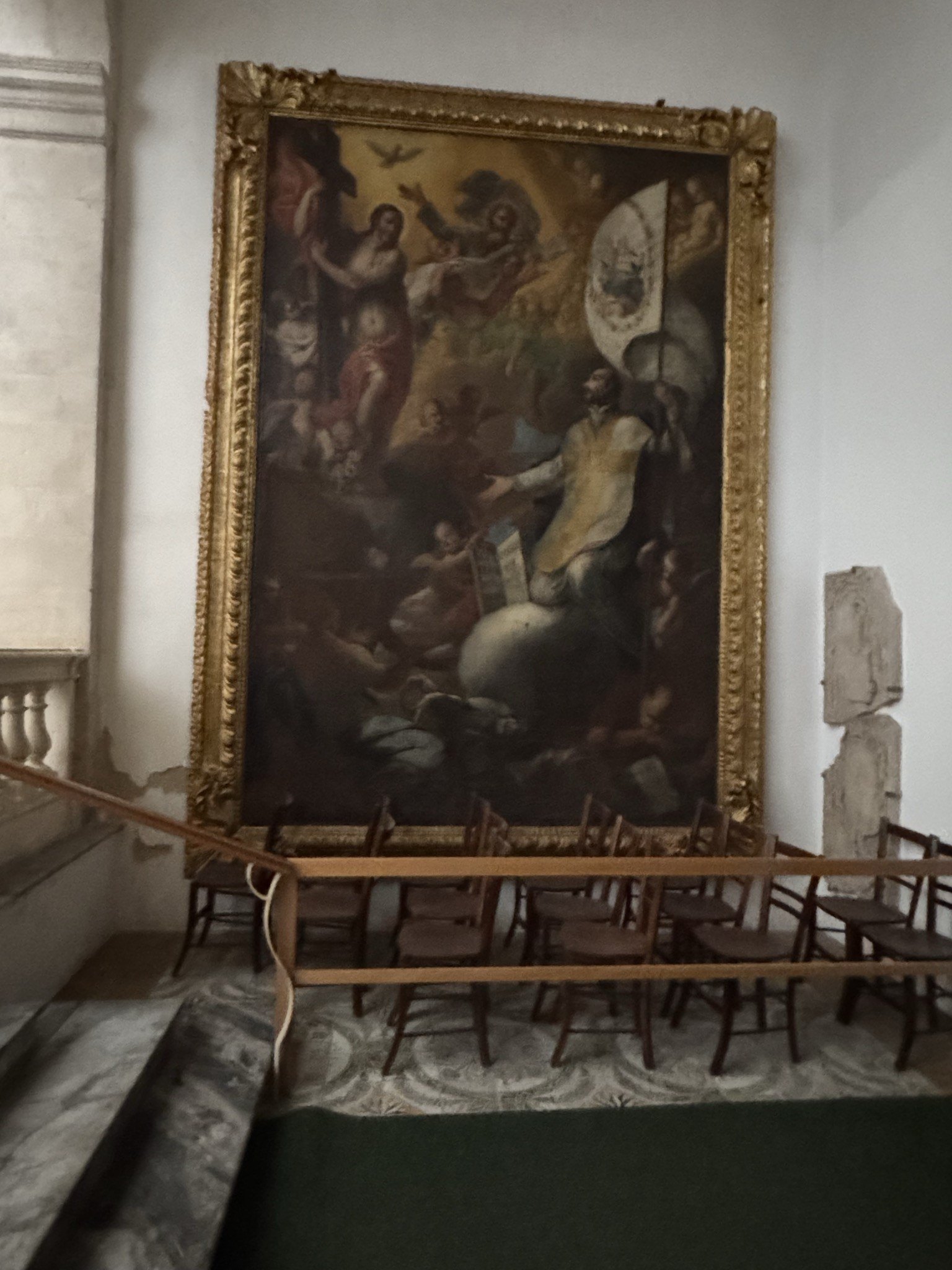 Tela settecentesca in cornice dorata intagliata appoggiata in chiesa, scena religiosa con figure e angeli.