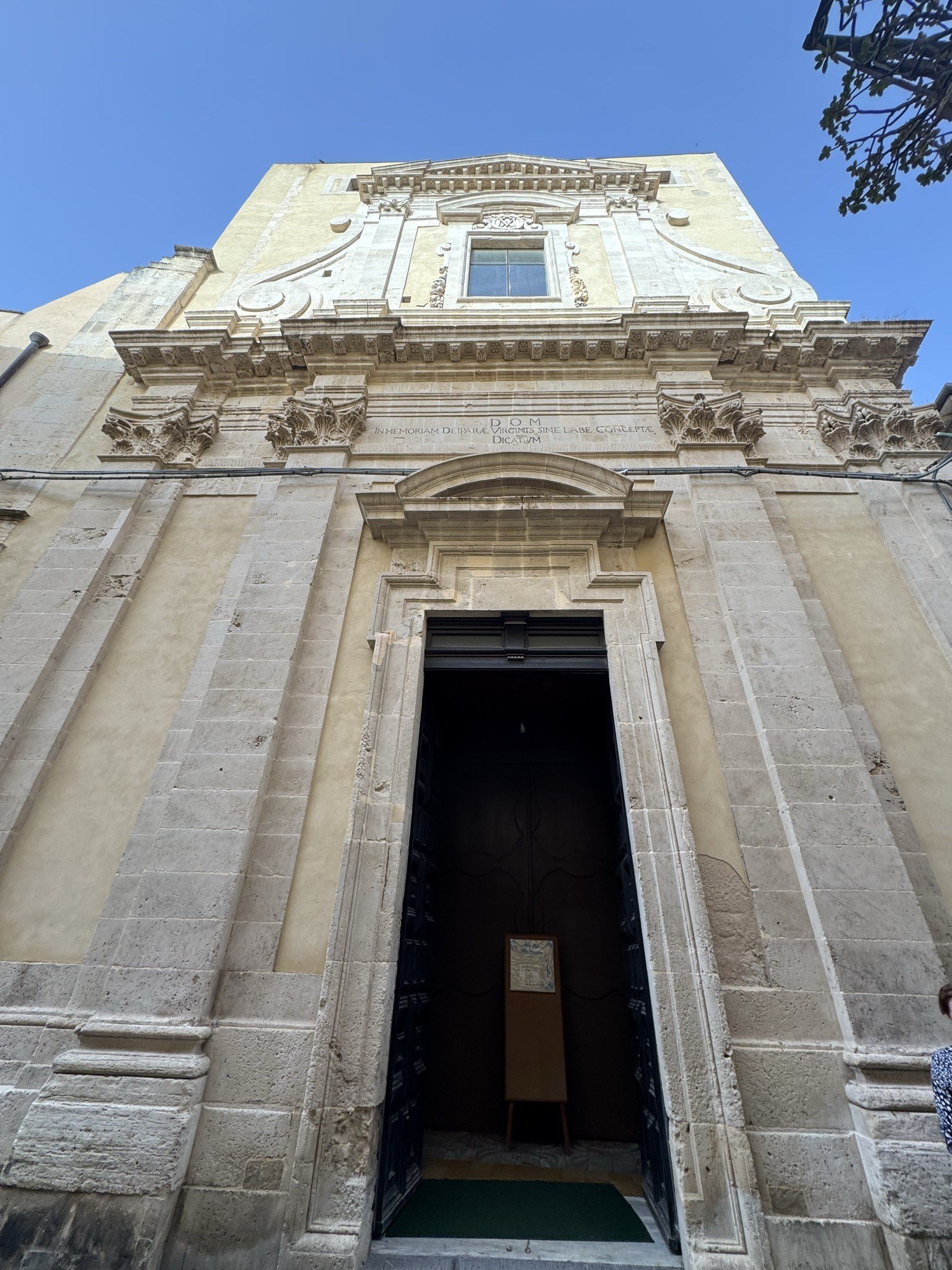 Facciata in pietra calcarea della chiesa di Santa Maria della Concezione su via Roma, con portale architravato barocco, finestrone centrale e coronamento mosso.