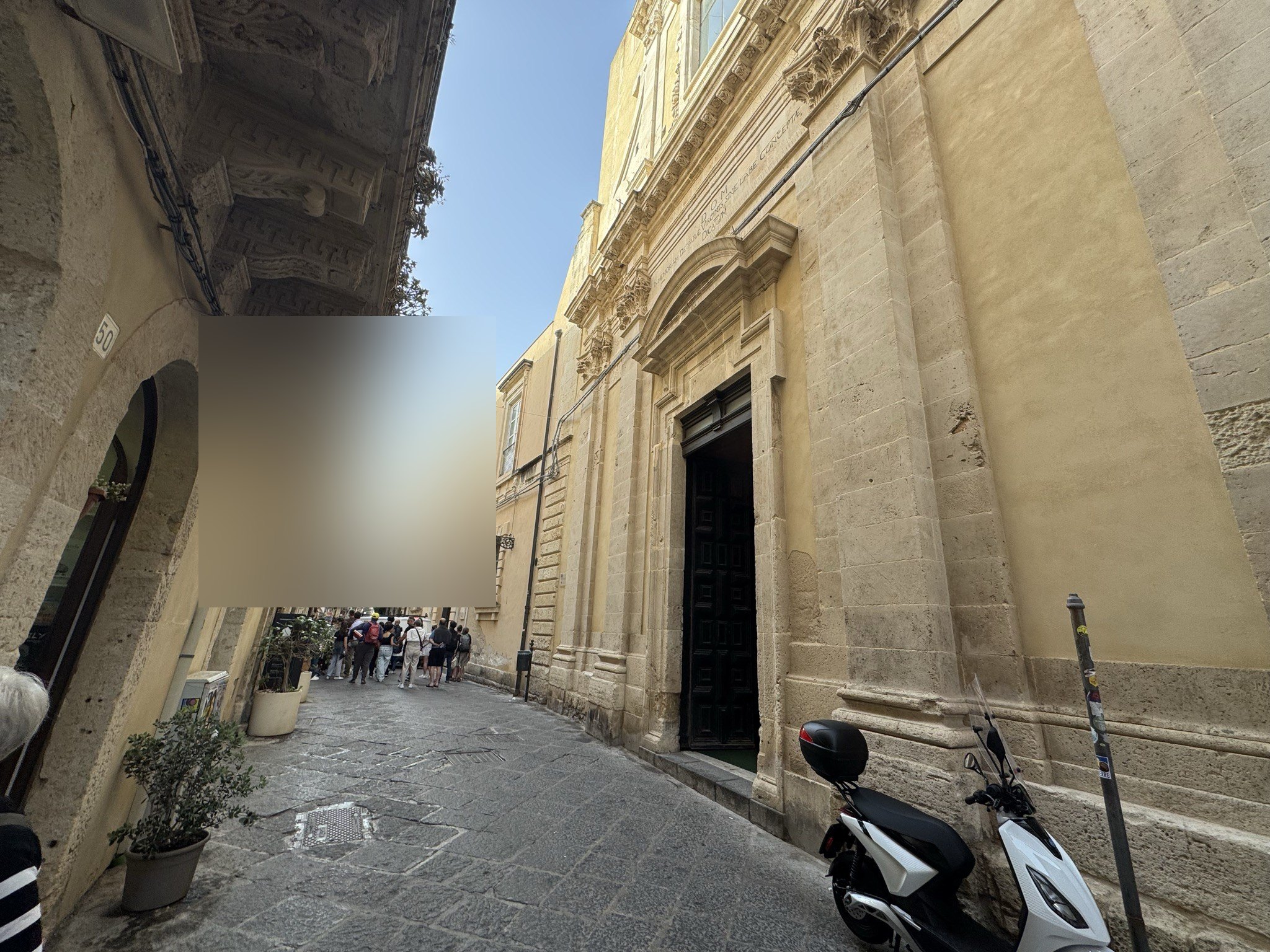 Vista della chiesa lungo via Roma, con il portale laterale a destra e l'asse stretto di Ortigia che prosegue verso il Duomo.