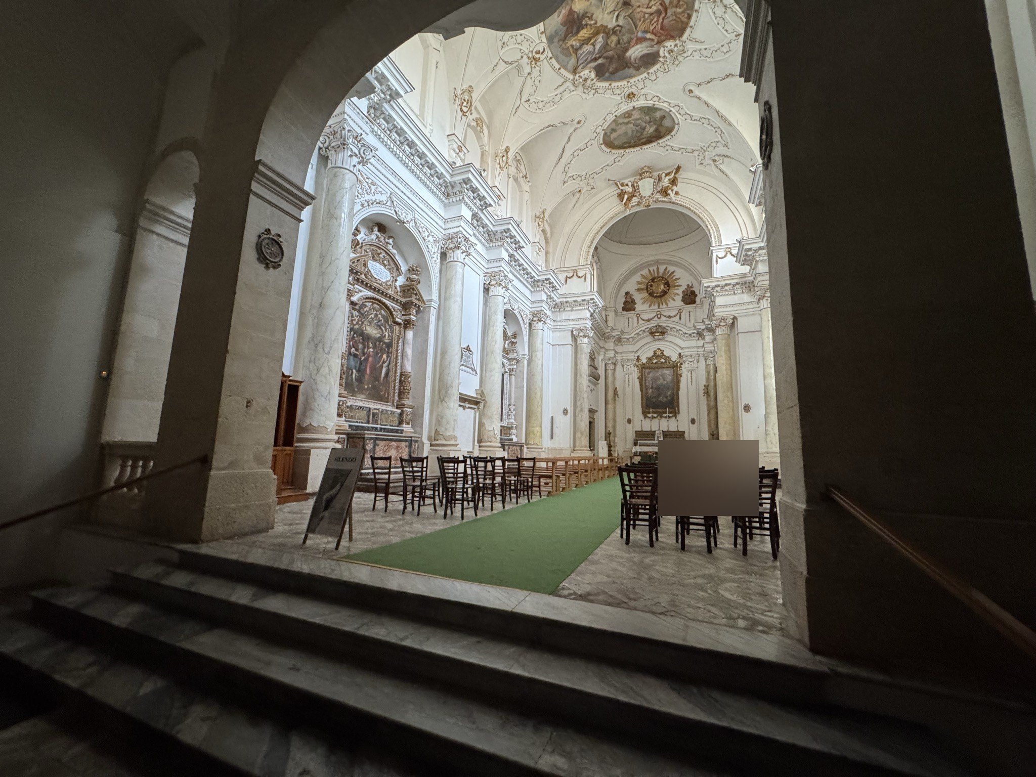 Vista dell'interno della chiesa di Santa Maria della Concezione da sopra la breve scalinata d'ingresso: navata unica con volta a botte affrescata, altari laterali e abside con altare maggiore sormontato dal grande sole raggiato.