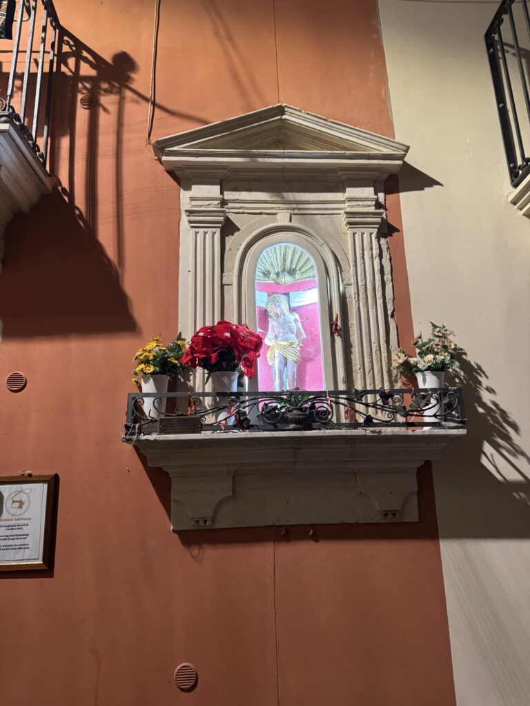 L'edicola votiva di San Sebastiano martire al civico 21 di via Dione, Ortigia, in luce serale