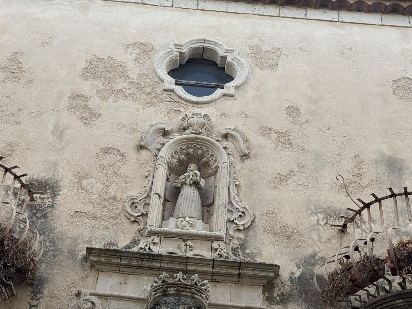 Vista frontale completa dell'edicola di Sant'Antonio di Padova in via Vittorio Veneto 41 Ortigia con la cornice barocca scolpita e l'oculus mistilineo polilobato soprastante