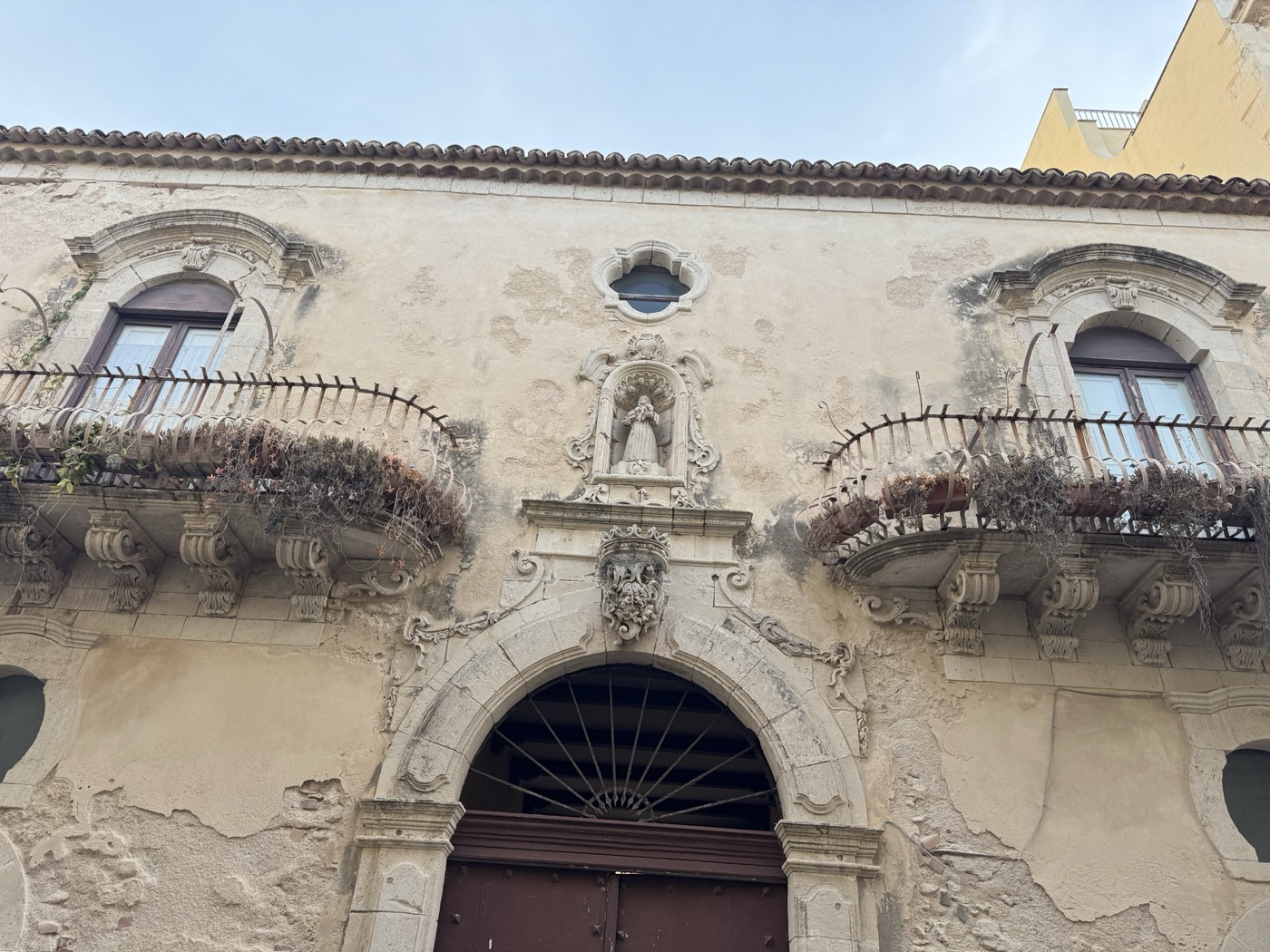 Prospetto di Palazzo Mezio-Blanco in via Vittorio Veneto 41 Ortigia con edicola votiva di Sant'Antonio di Padova sopra il portone centrale, balconi a panza con mensole figurate