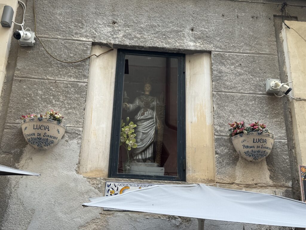 Vista frontale dell'edicola votiva di Santa Lucia in via Cavour 15 a Ortigia, con i due vasi in maiolica recanti la scritta «LUCIA Patrona di Siracusa»