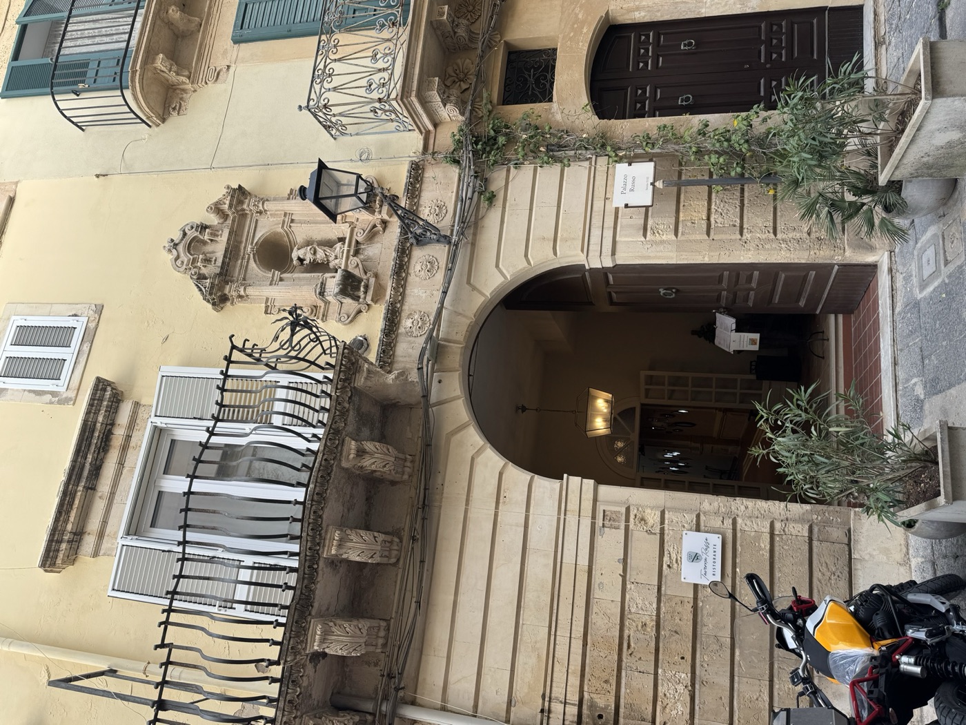 Vista urbana laterale di Palazzo Russo in via Vittorio Veneto 22 Ortigia, con prospetto a tre livelli, balconi a panza e edicola votiva di Santa Lucia in posizione elevata