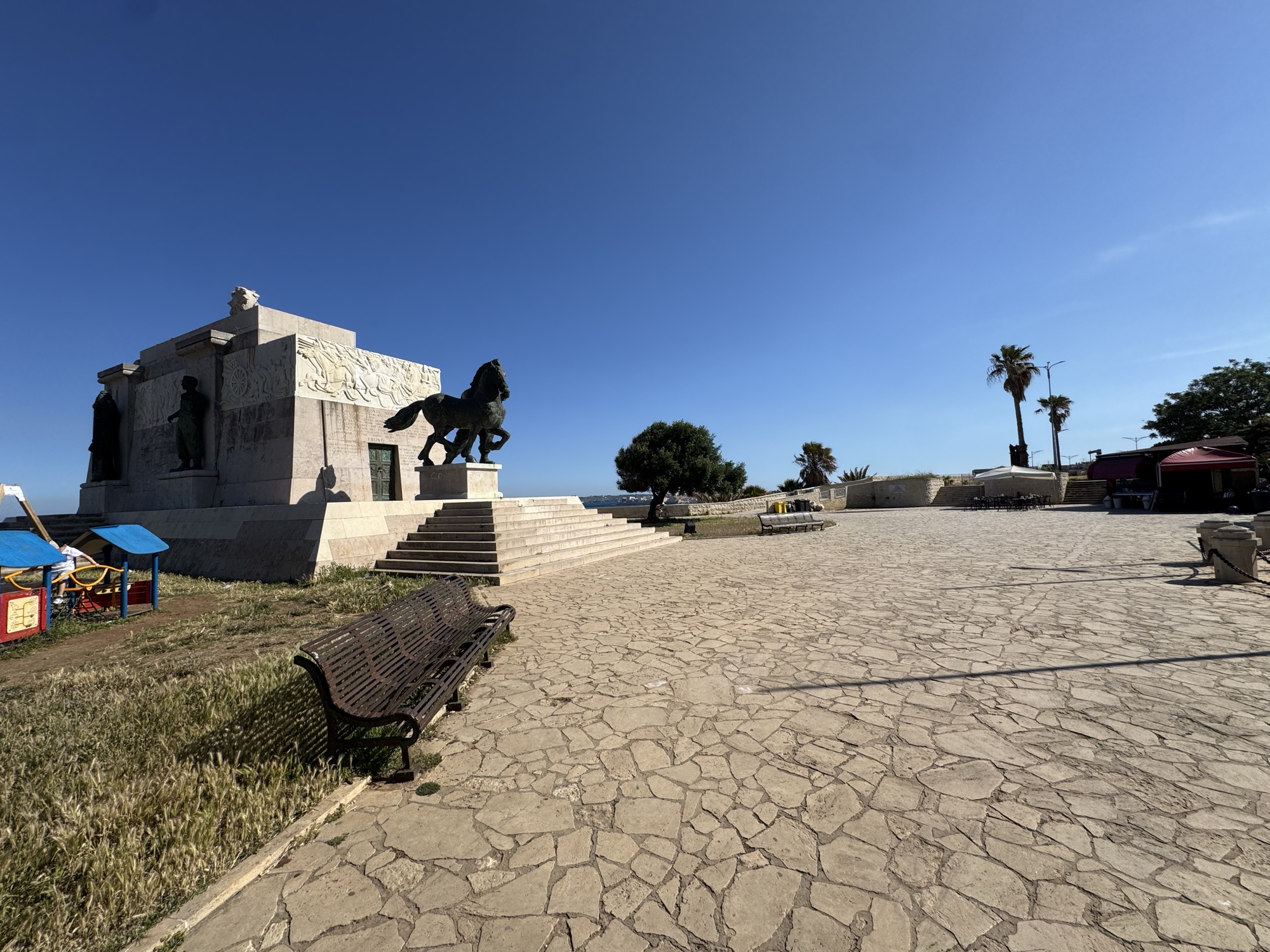 Veduta del monumento dalla piazza dei Cappuccini con la pavimentazione lastricata e la pista ciclabile Rossana Maiorca