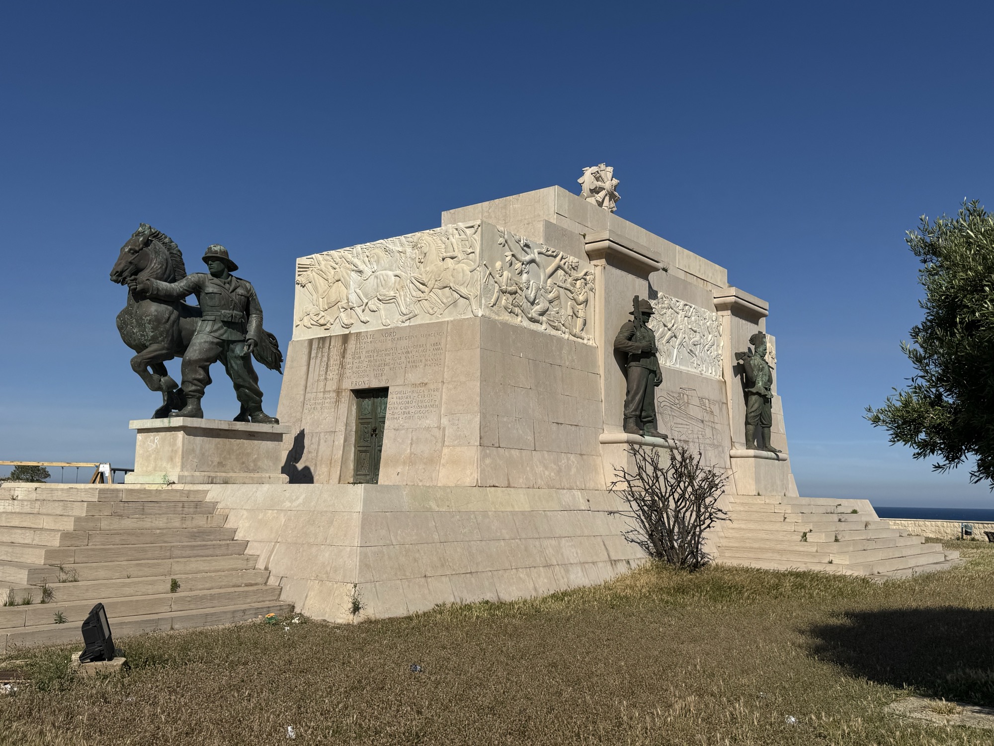 Veduta tre quarti del monumento con il cavallo bronzeo, le statue dei militari e dei lavoratori e i bassorilievi marmorei