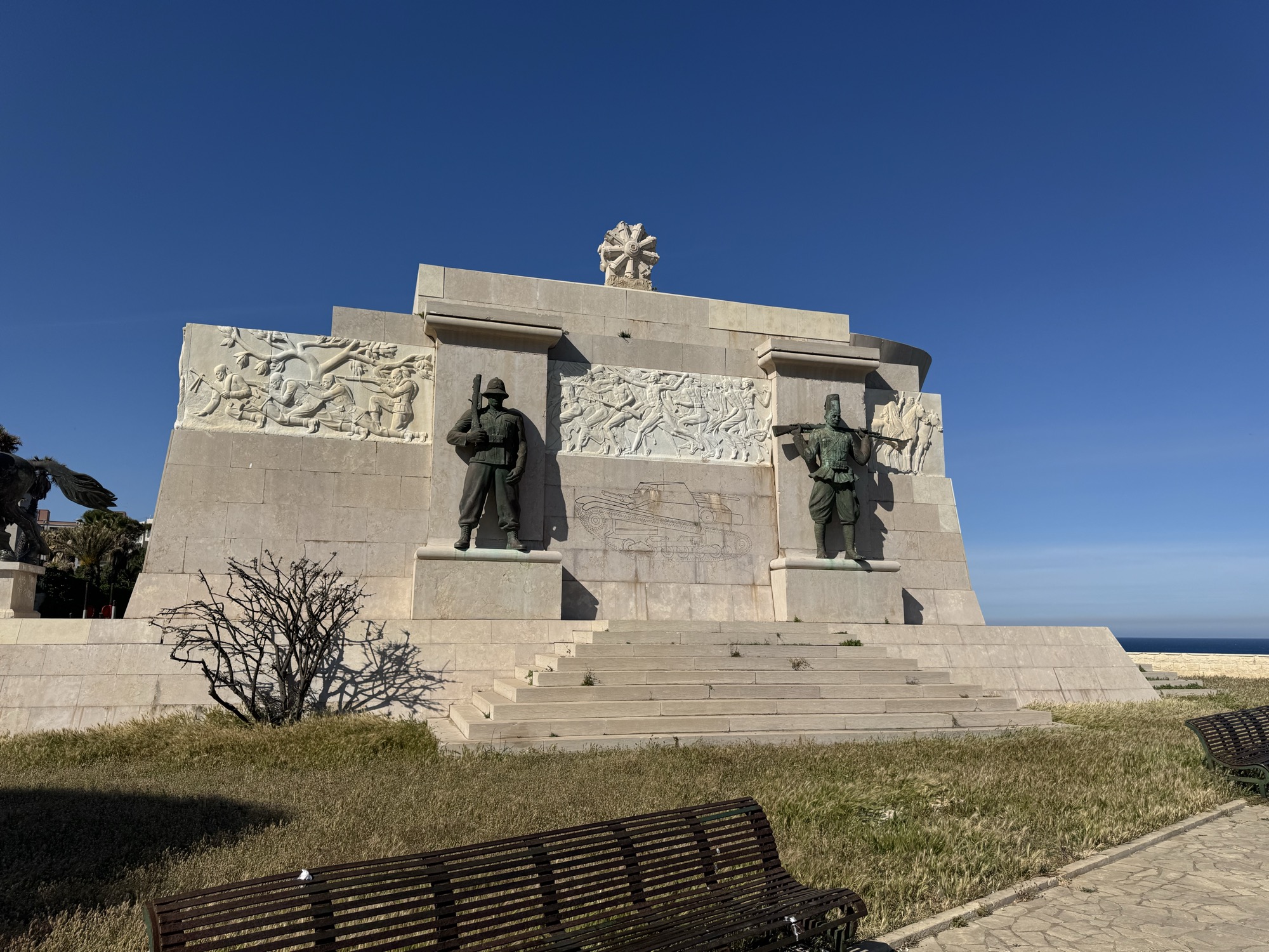 Vista frontale del Monumento ai Caduti d'Africa a Siracusa con le statue bronzee dei soldati e i bassorilievi marmorei