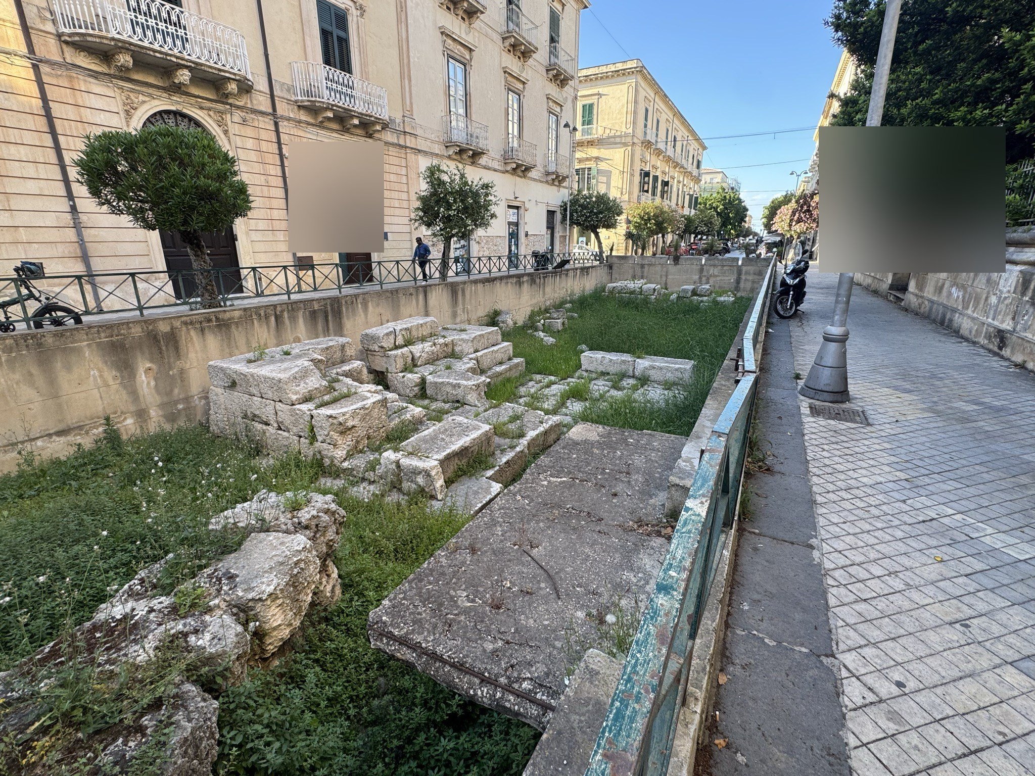 Blocchi calcarei superstiti del paramento laterale della Porta Urbica di Siracusa, visti dal marciapiede sopraelevato.