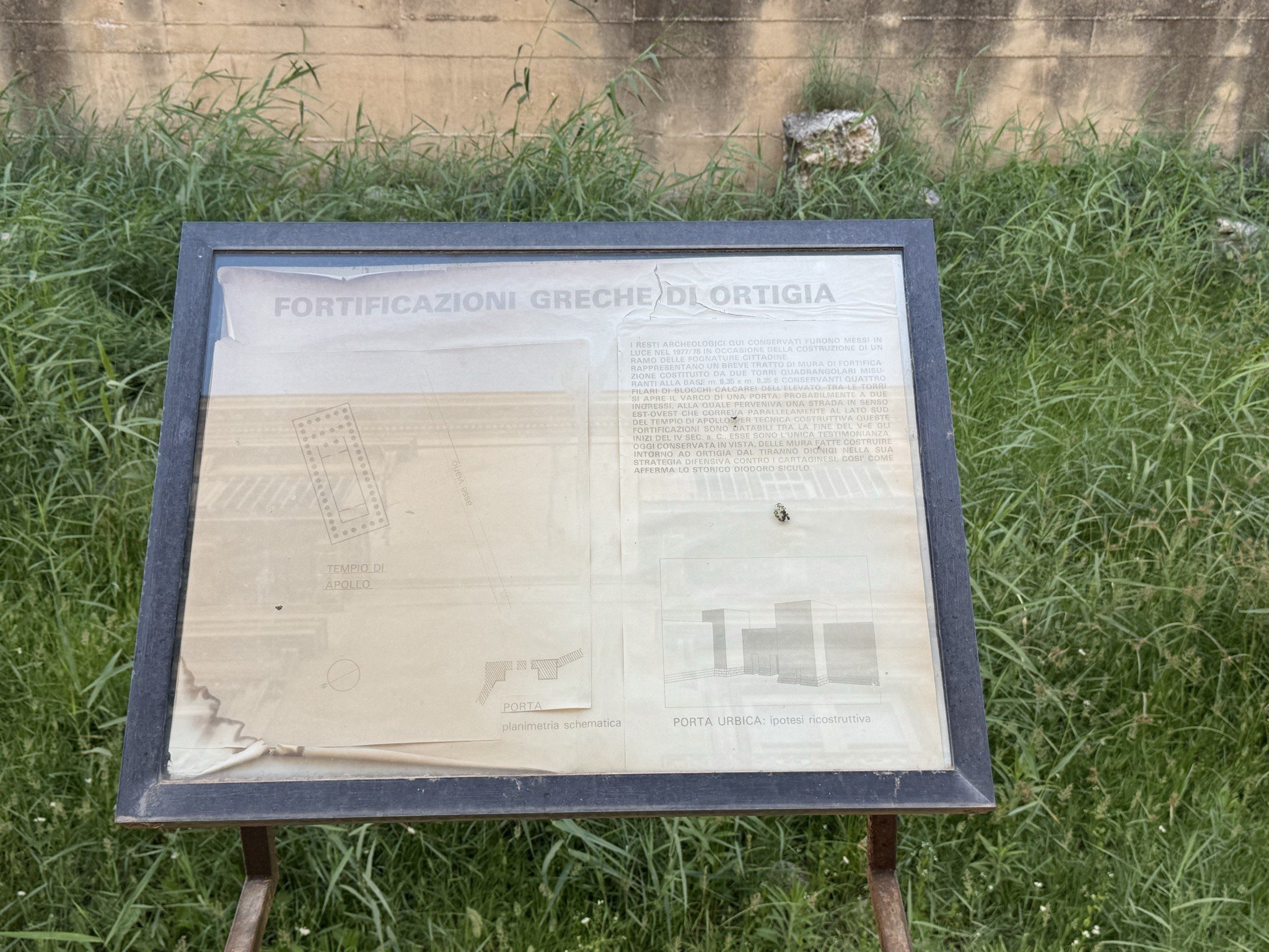 Pannello informativo in plexiglas con il titolo «Fortificazioni greche di Ortigia» e disegno tecnico con la sezione prospettica della Porta Urbica.