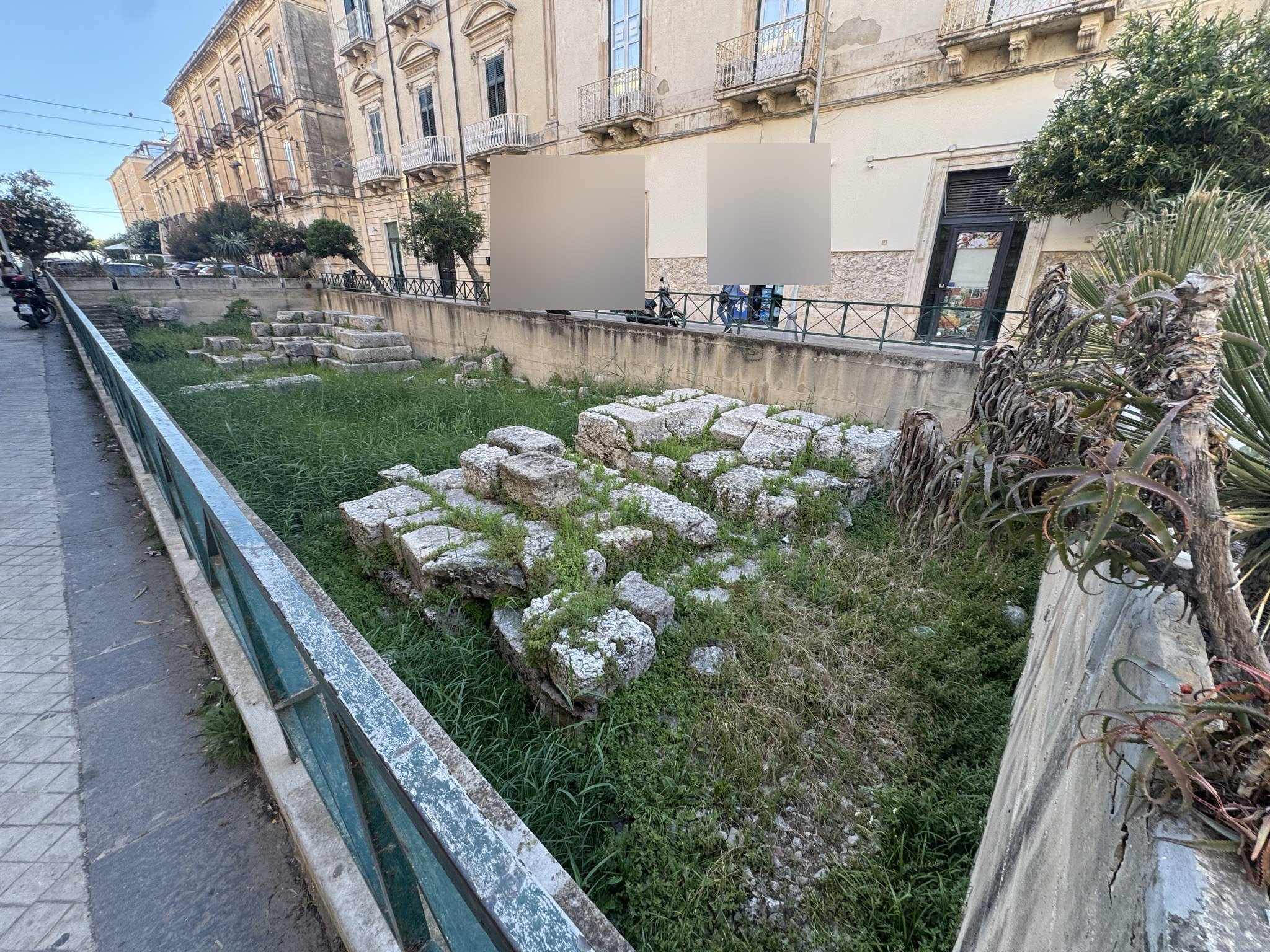 Panoramica dell'area archeologica della Porta Urbica di Siracusa con i blocchi calcarei in conca al di sotto del livello stradale, lungo via XX Settembre a Ortigia.