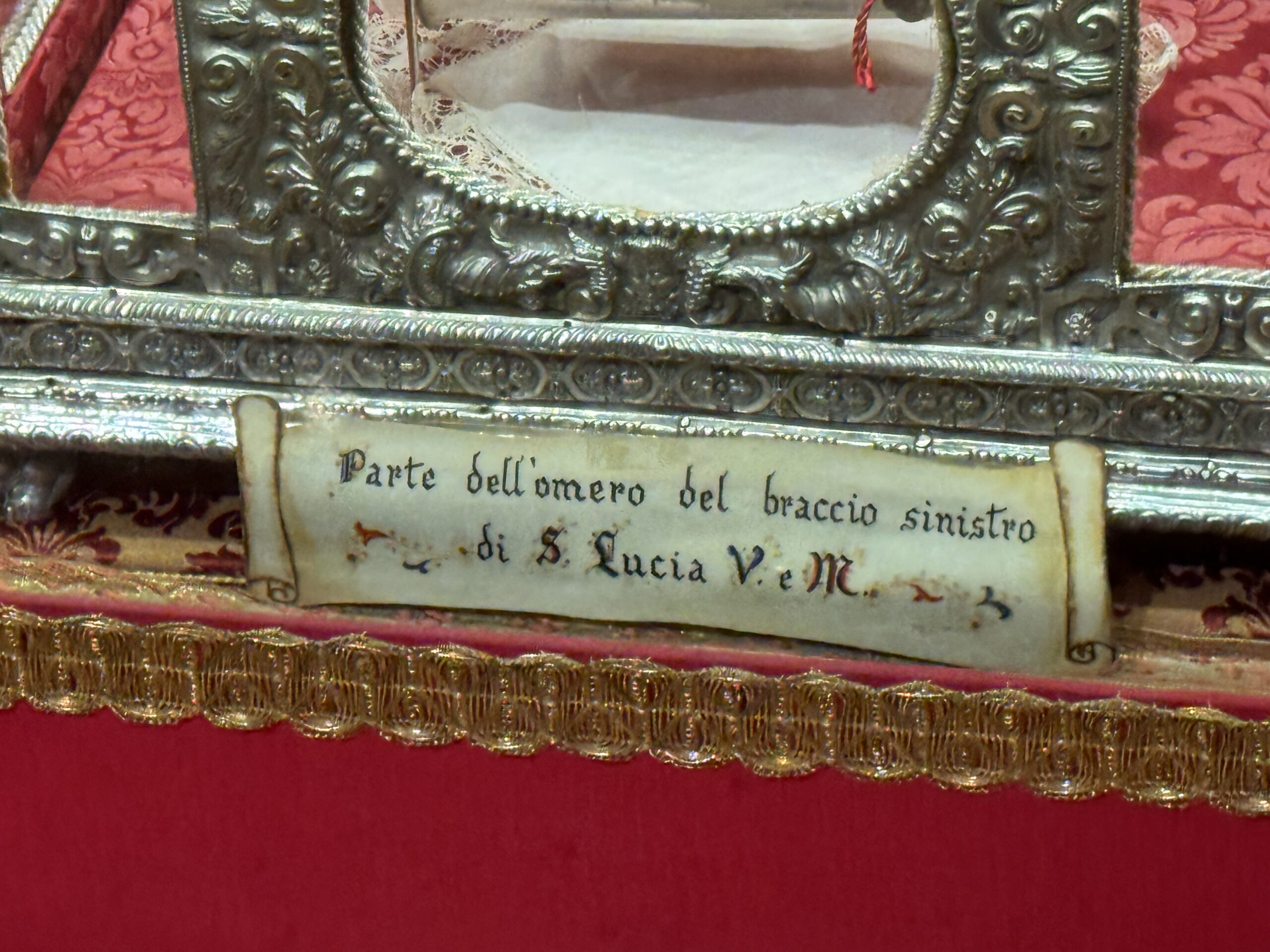 Targhetta in marmo con la scritta a mano Parte dell'omero del braccio sinistro di S. Lucia V. e M.