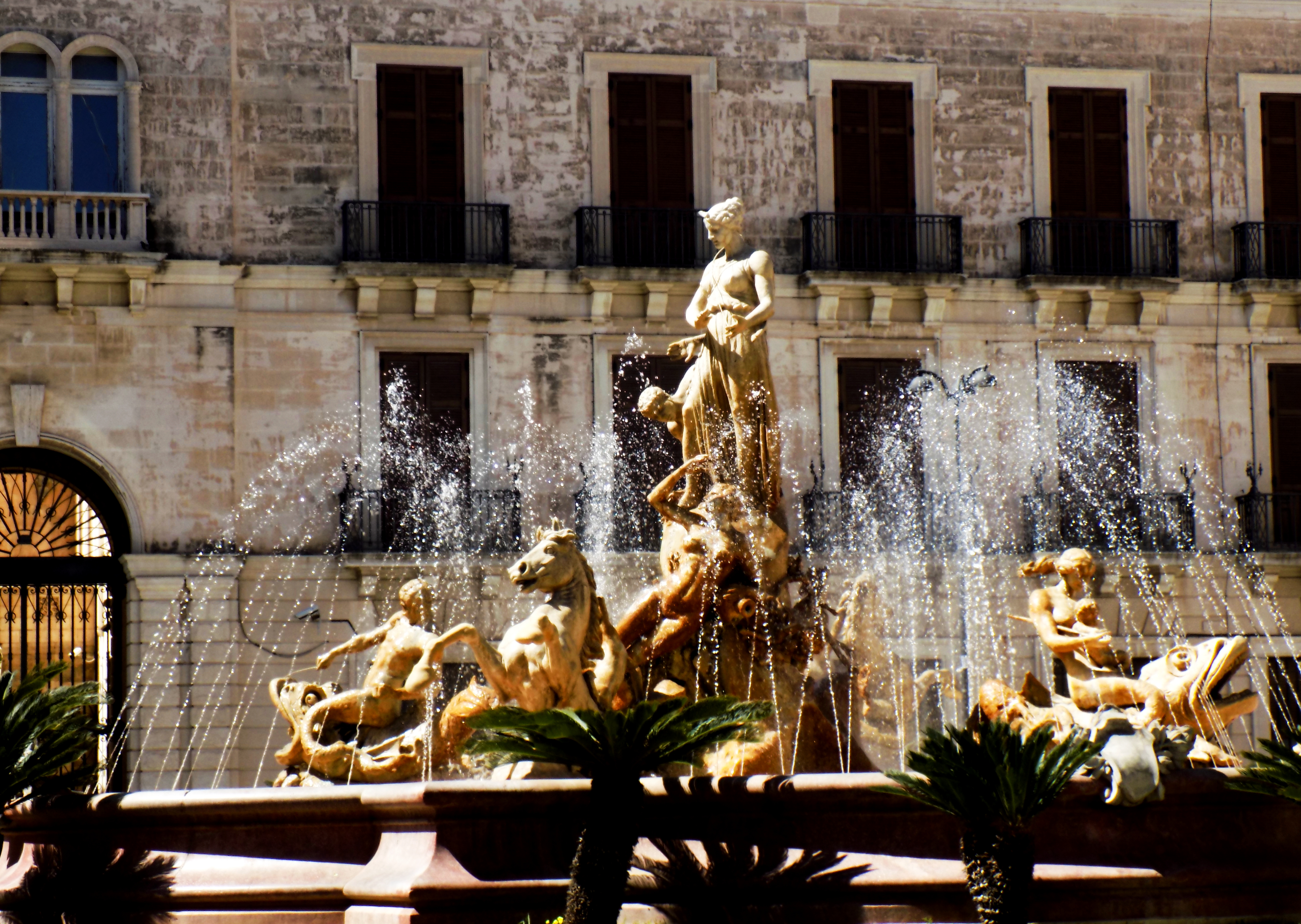 La Fontana di Diana in piazza Archimede, con la statua della dea e i gruppi di tritoni, davanti al palazzo dell'Orologio