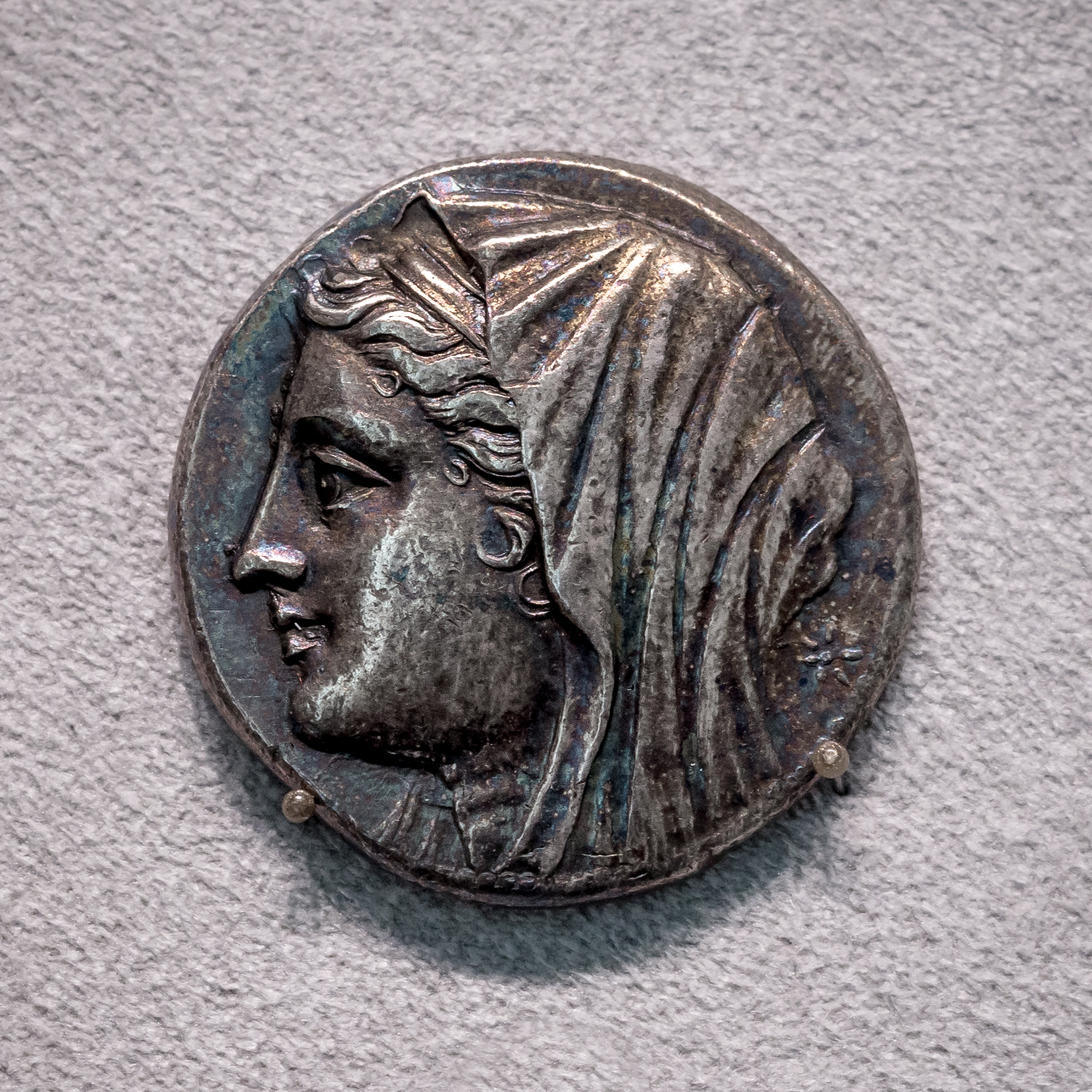 Testa velata e diademata della regina Filistide su un argento da 16 litrai di Siracusa