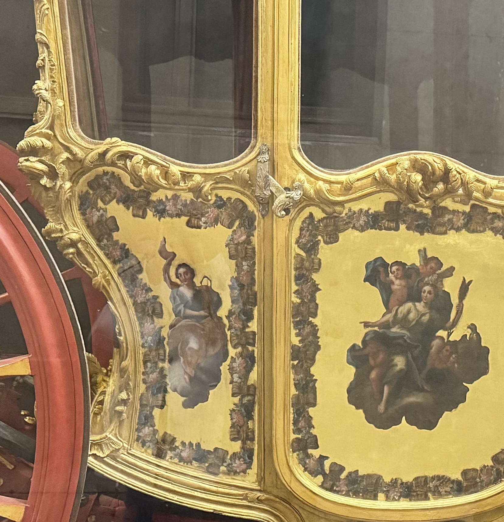 Dettaglio dei pannelli dipinti sulla cassa con figure allegoriche femminili su nuvole entro cornici dorate rococo e festoni floreali