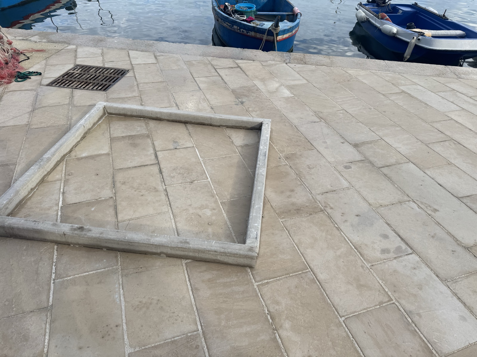 Un telaio metallico quadrato lasciato a terra sul piano pedonale in pietra dello Sbarcadero, non fissato.