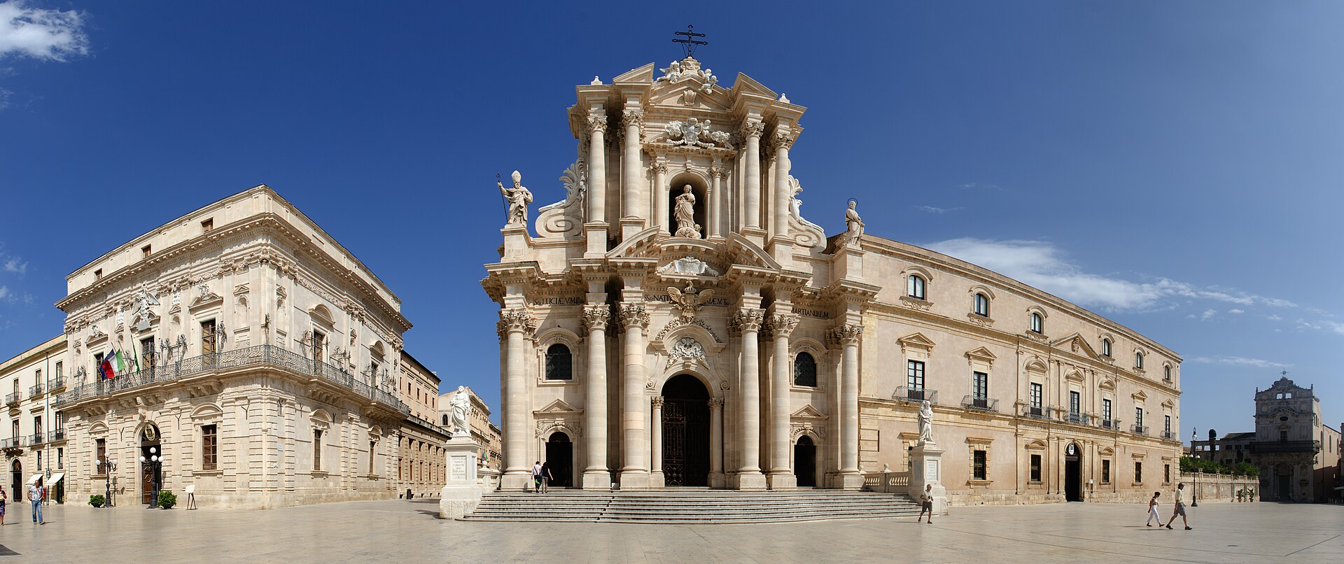 Veduta panoramica di piazza Duomo a Ortigia con la facciata barocca della Cattedrale al centro, il Palazzo del Senato a sinistra e il Palazzo Arcivescovile a destra