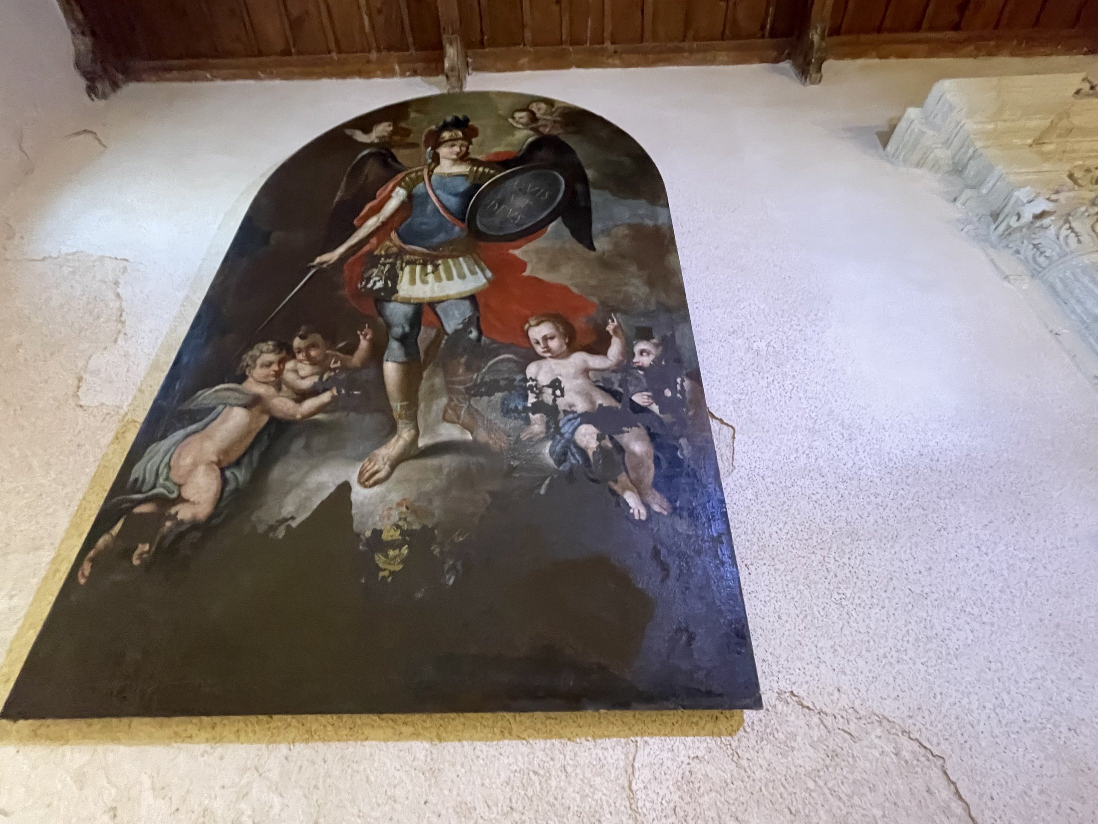 Grande tela centinata con San Michele arcangelo in armatura, spada e scudo, circondato da putti su fondo scuro